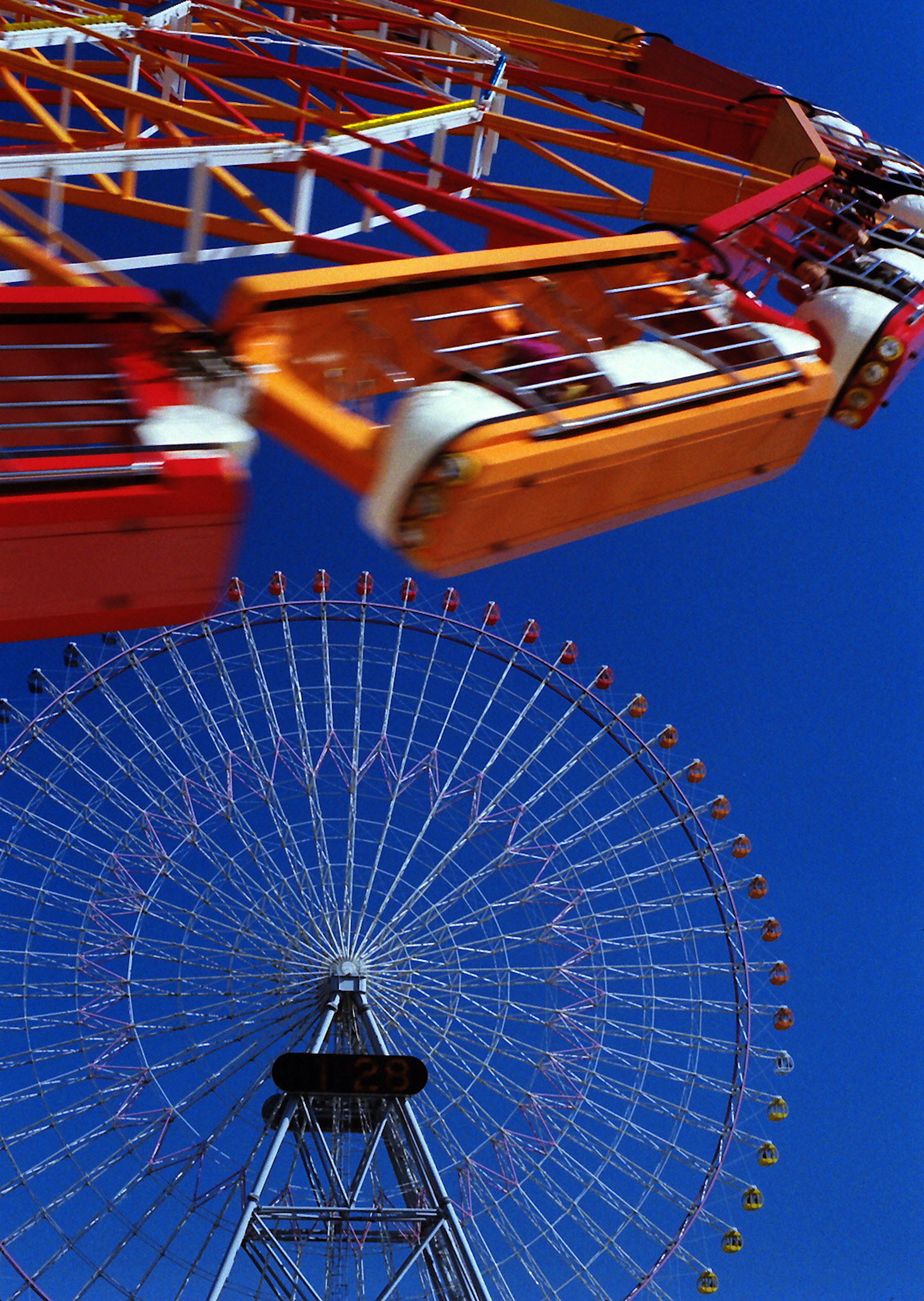 Parte di una ruota panoramica che gira sotto un cielo blu chiaro