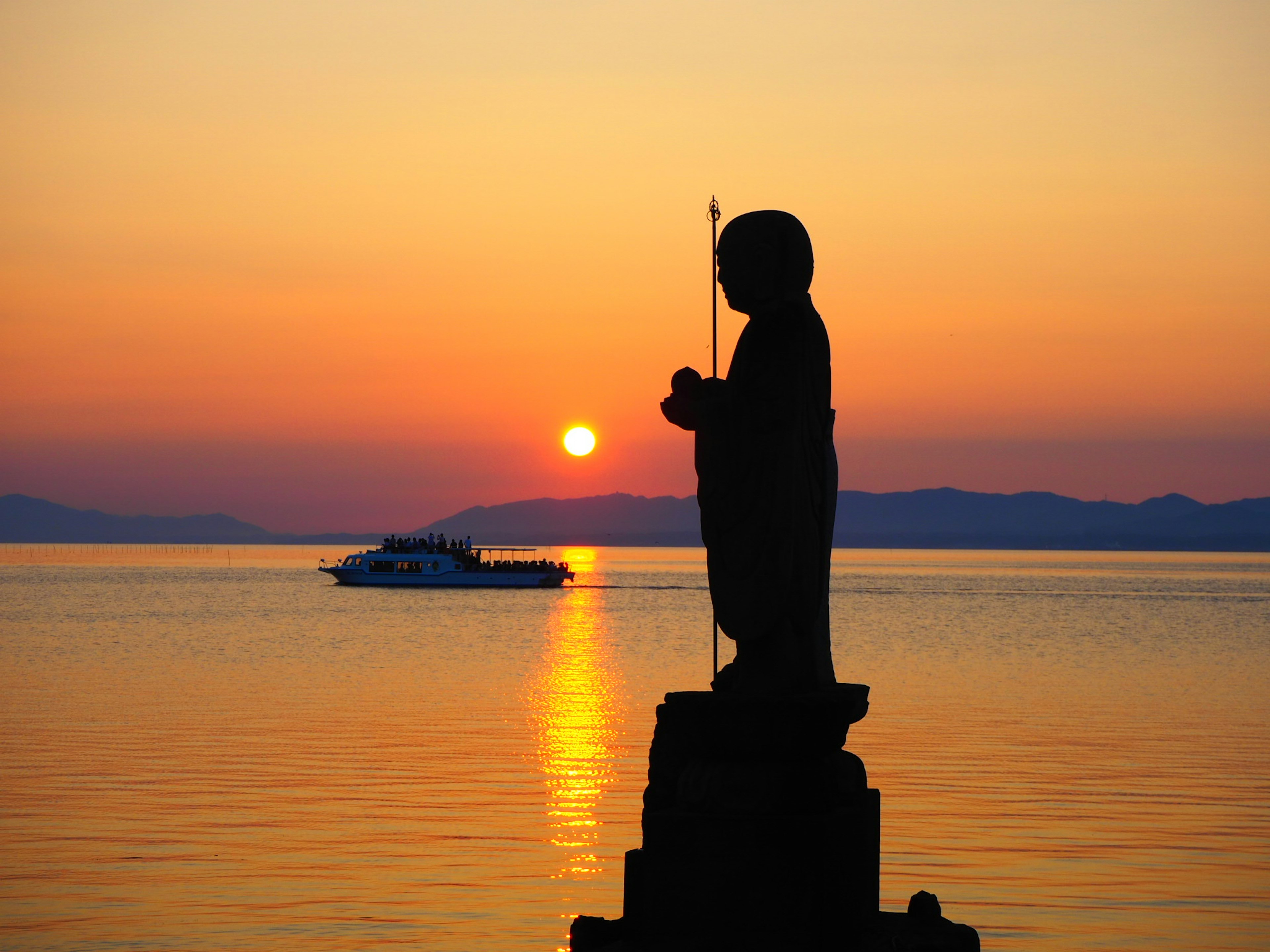 海に面した夕日を背にした像のシルエット