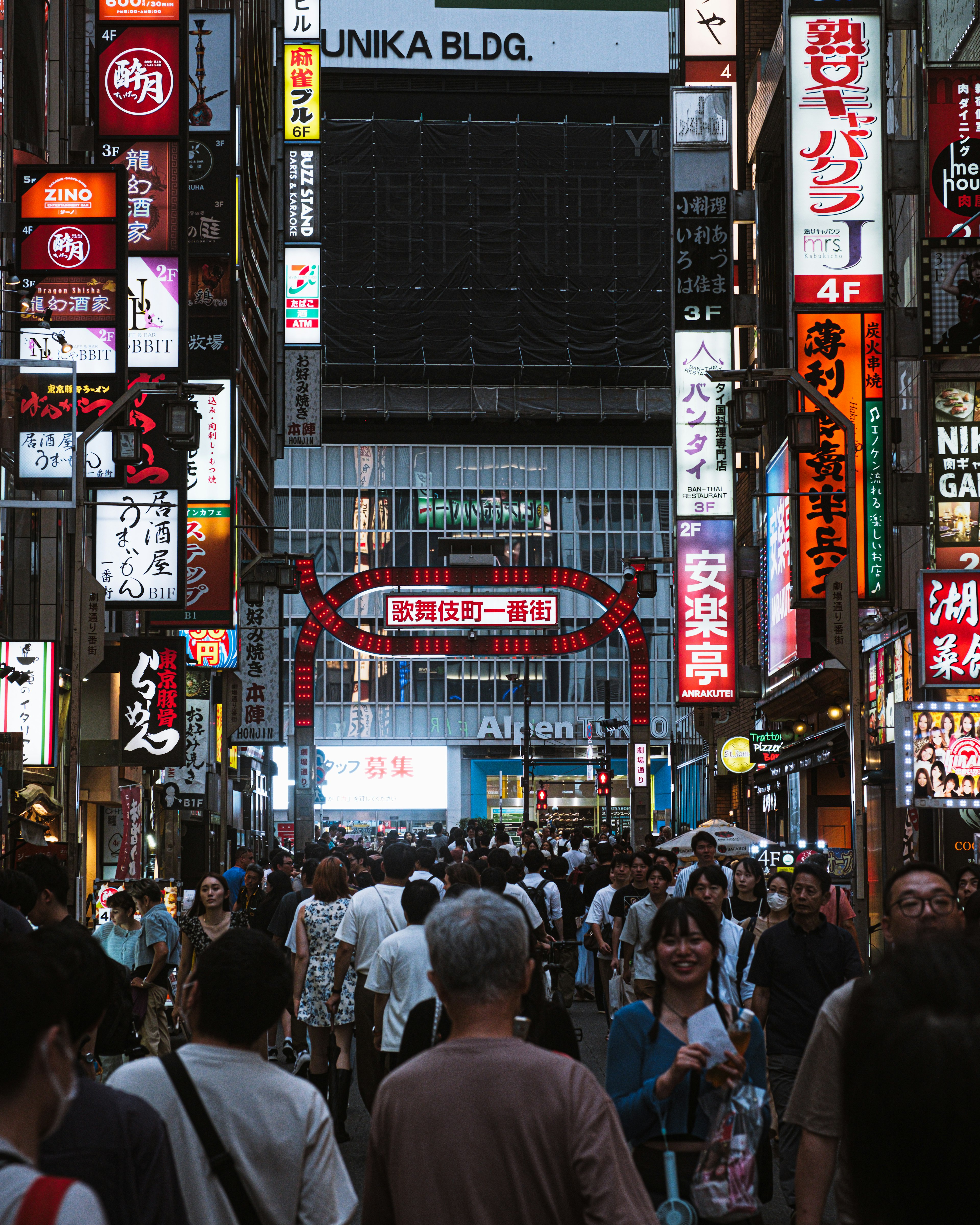 Crowded urban street filled with people and bright neon signs