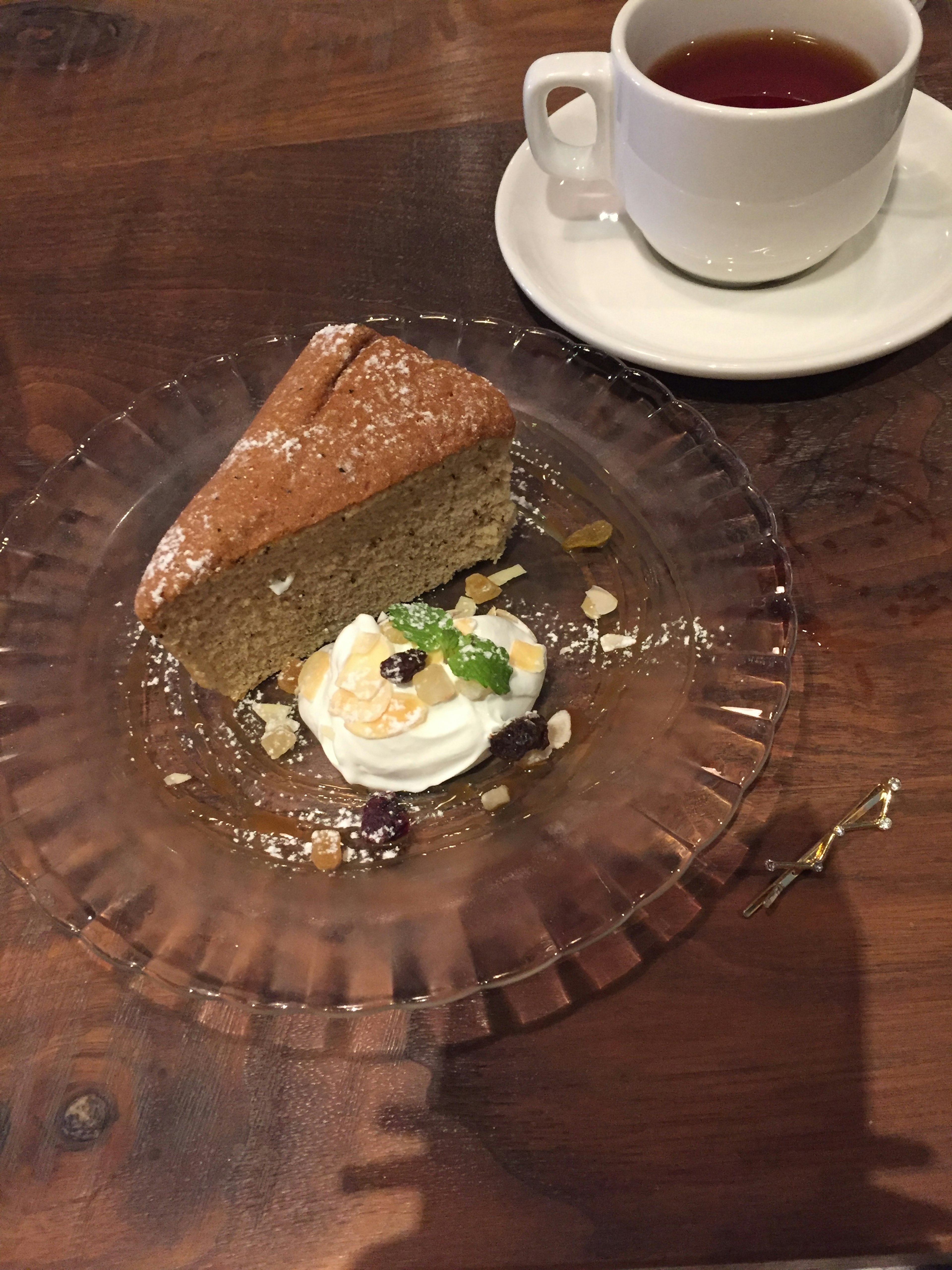 Rebanada de pastel con crema batida y taza de té