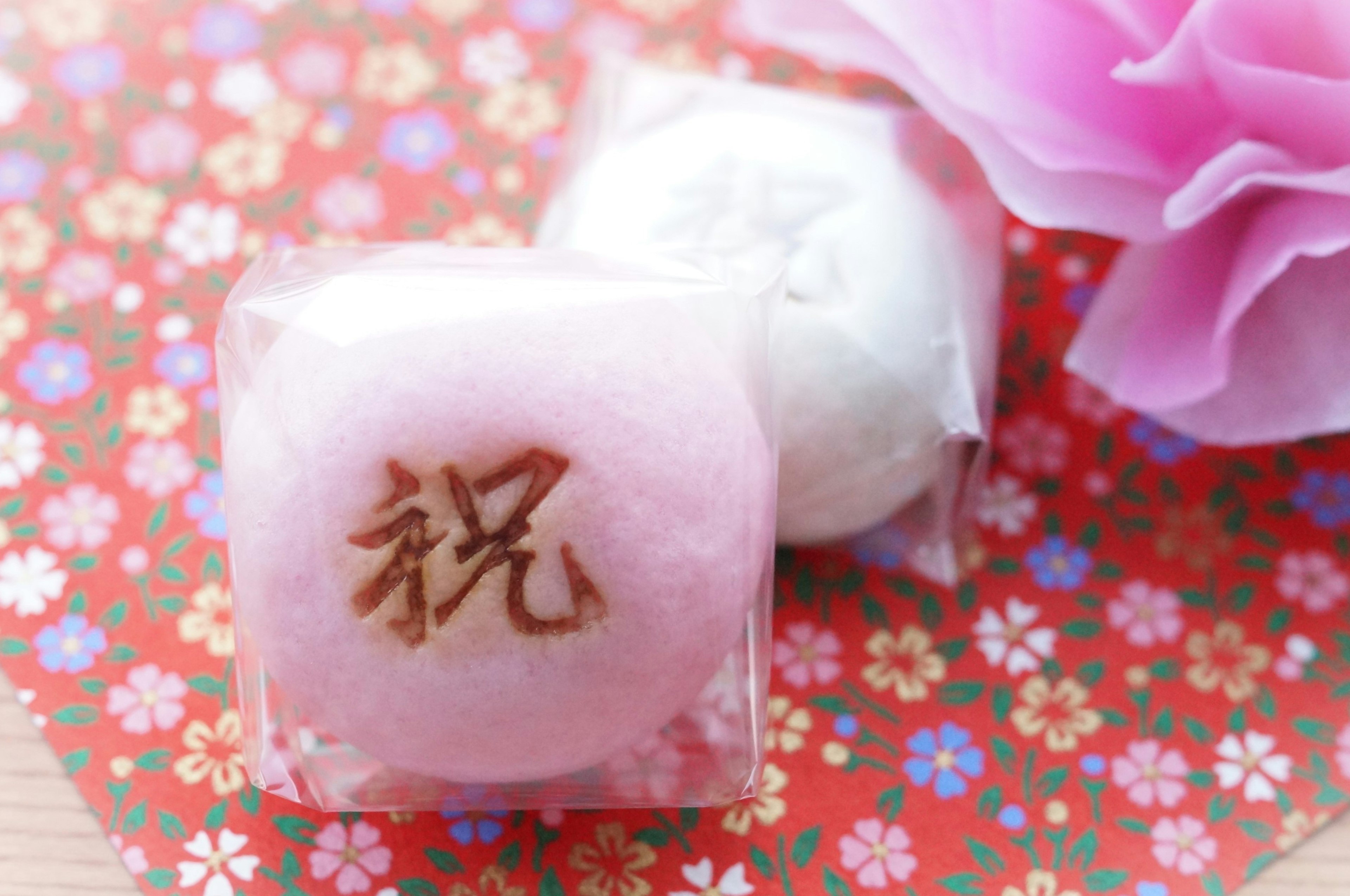 Pink and white Japanese sweets on a colorful floral patterned background