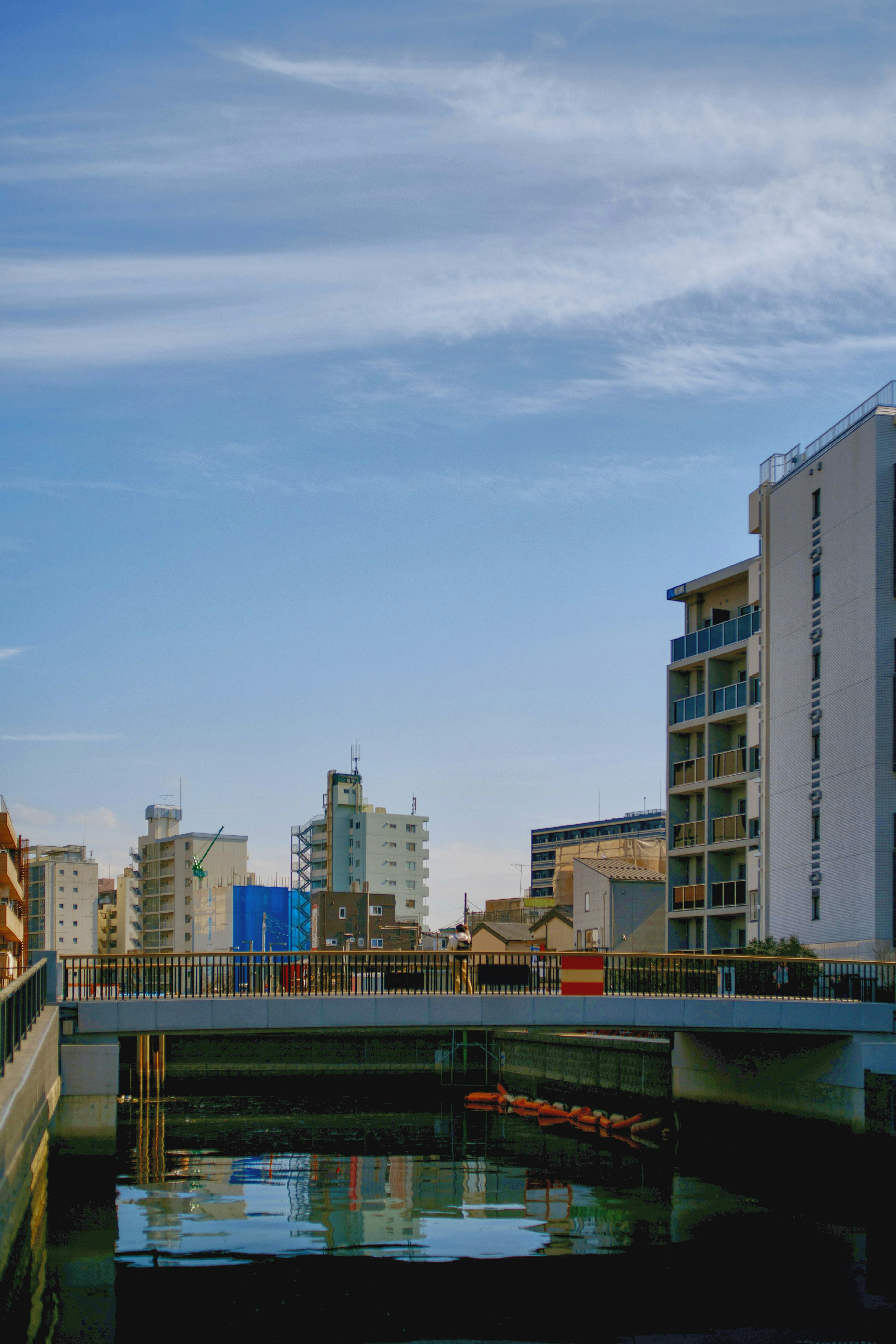 Tranquil waters reflecting a clear sky and modern buildings