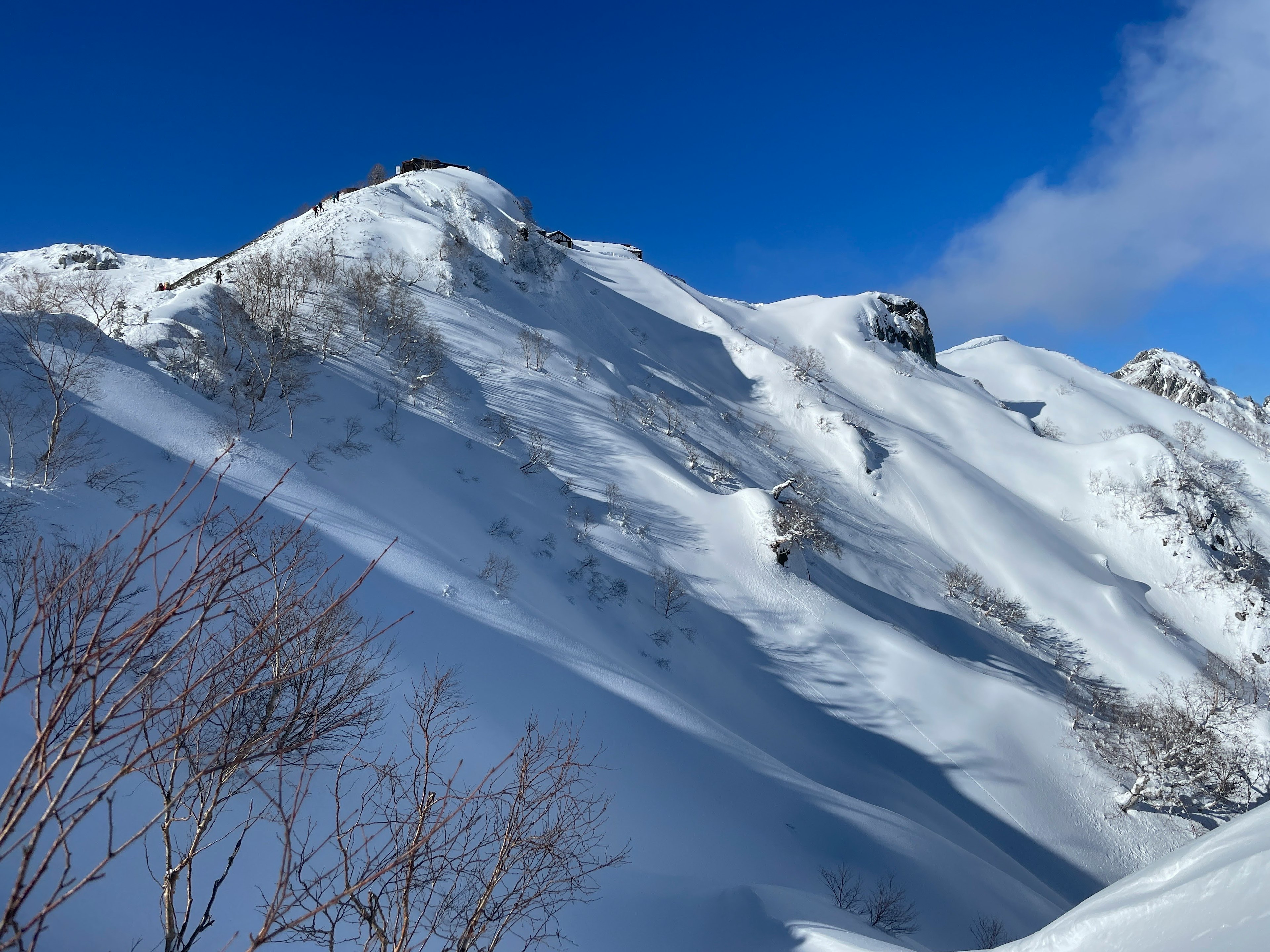 雪覆盖的山坡下的晴朗蓝天