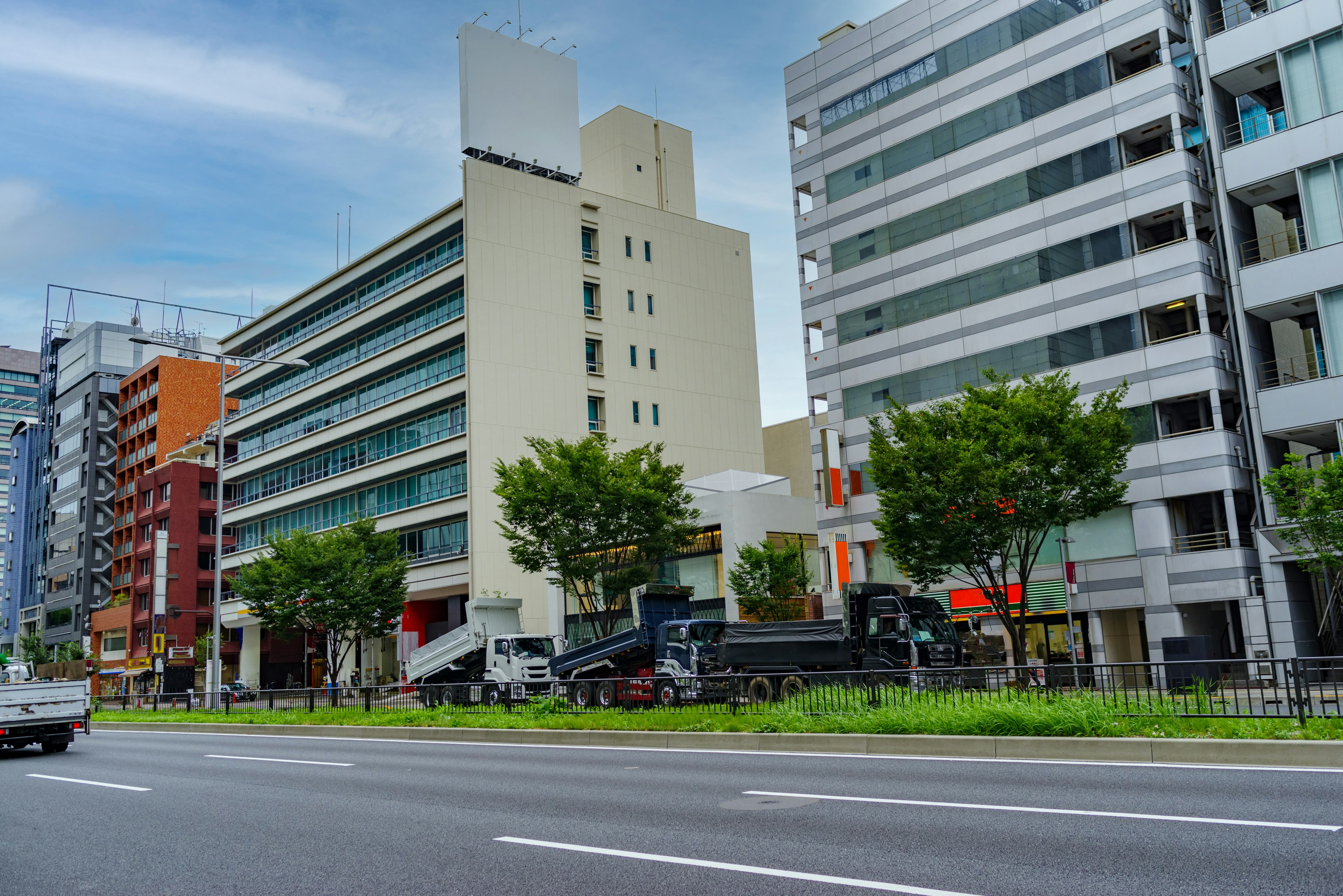 Edificios modernos a lo largo de una calle urbana con árboles verdes