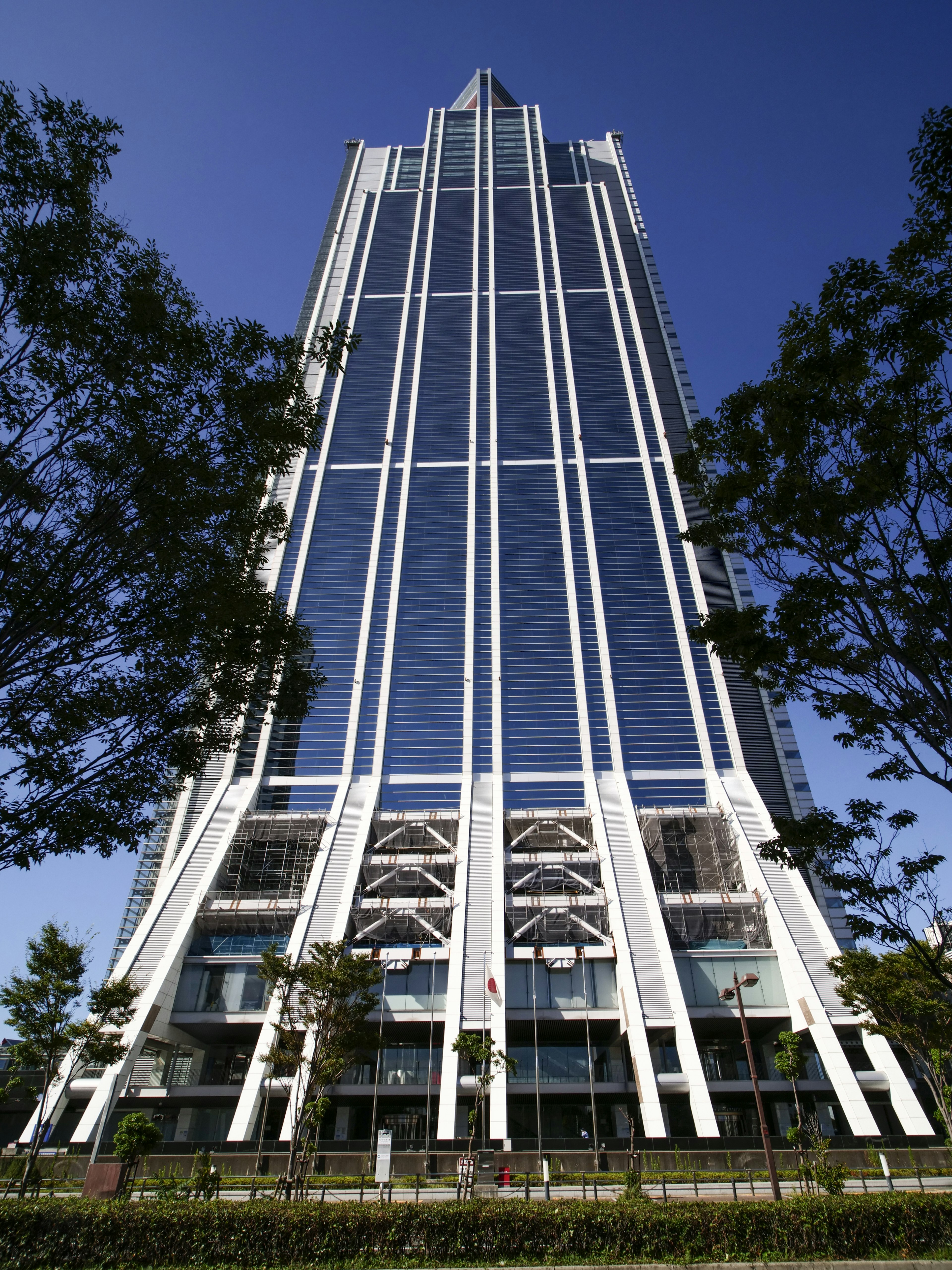 A modern skyscraper viewed from below against a clear blue sky