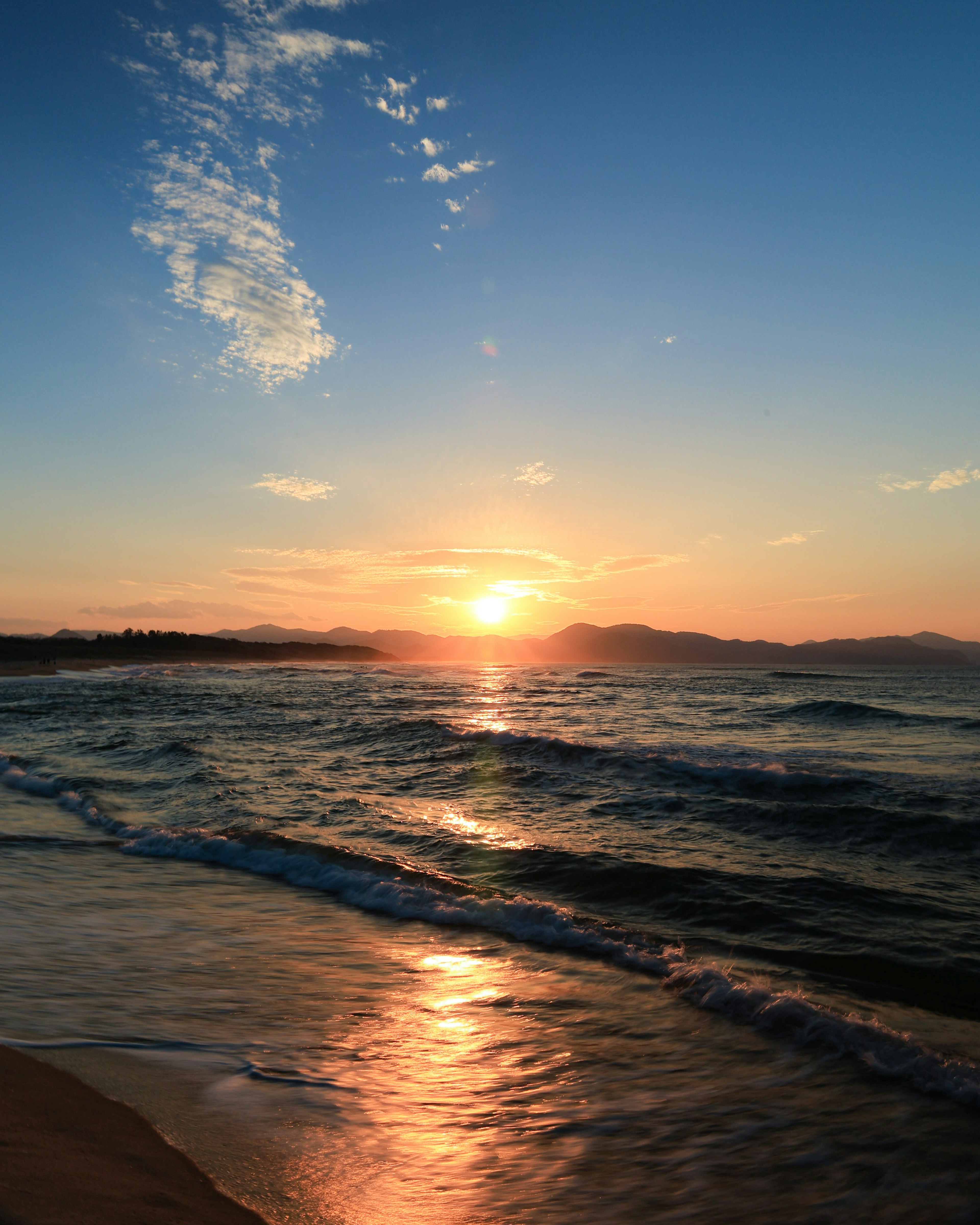 美しい夕日が海に沈む風景波の反射が金色に輝く