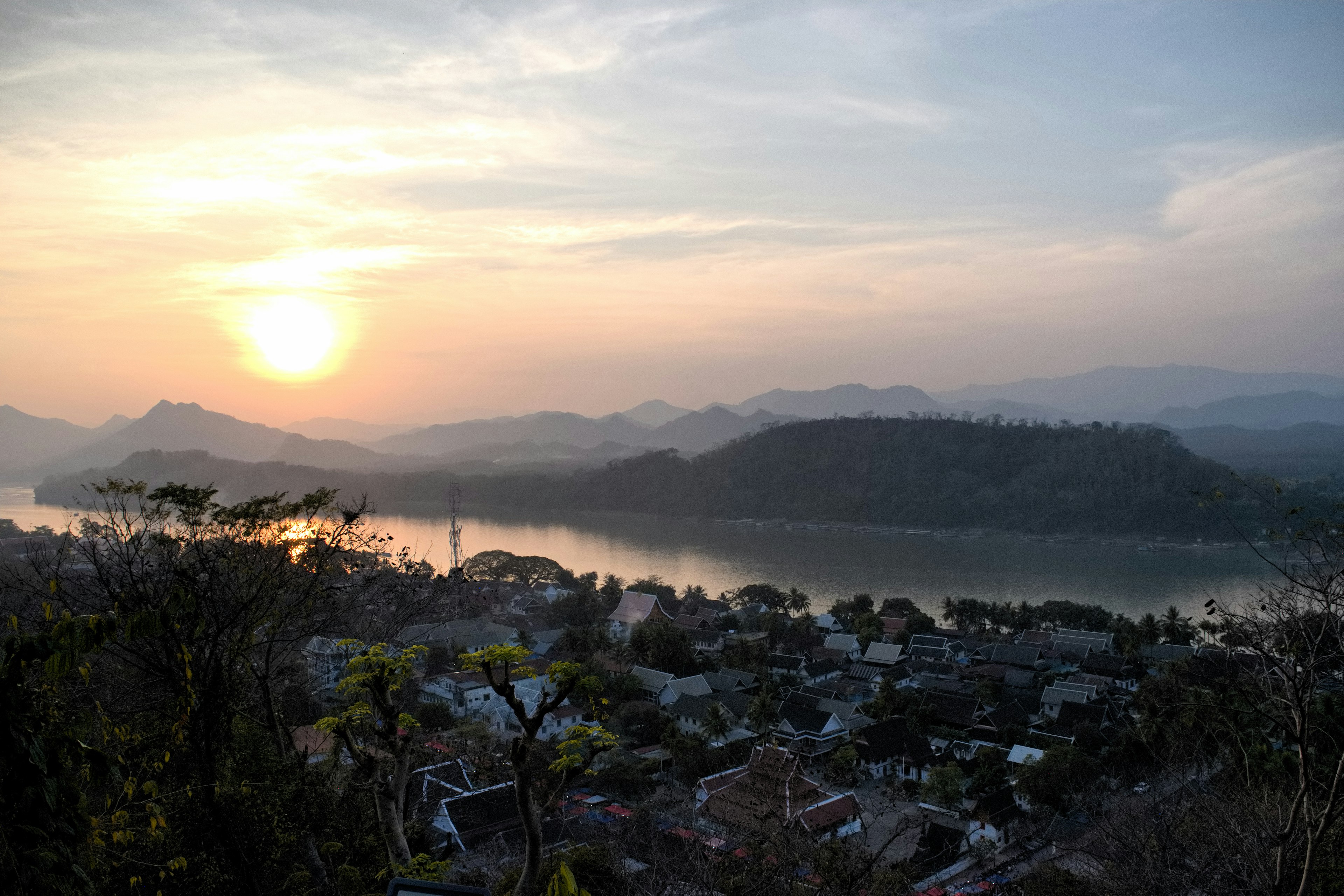 Pemandangan matahari terbenam di atas gunung dan sungai