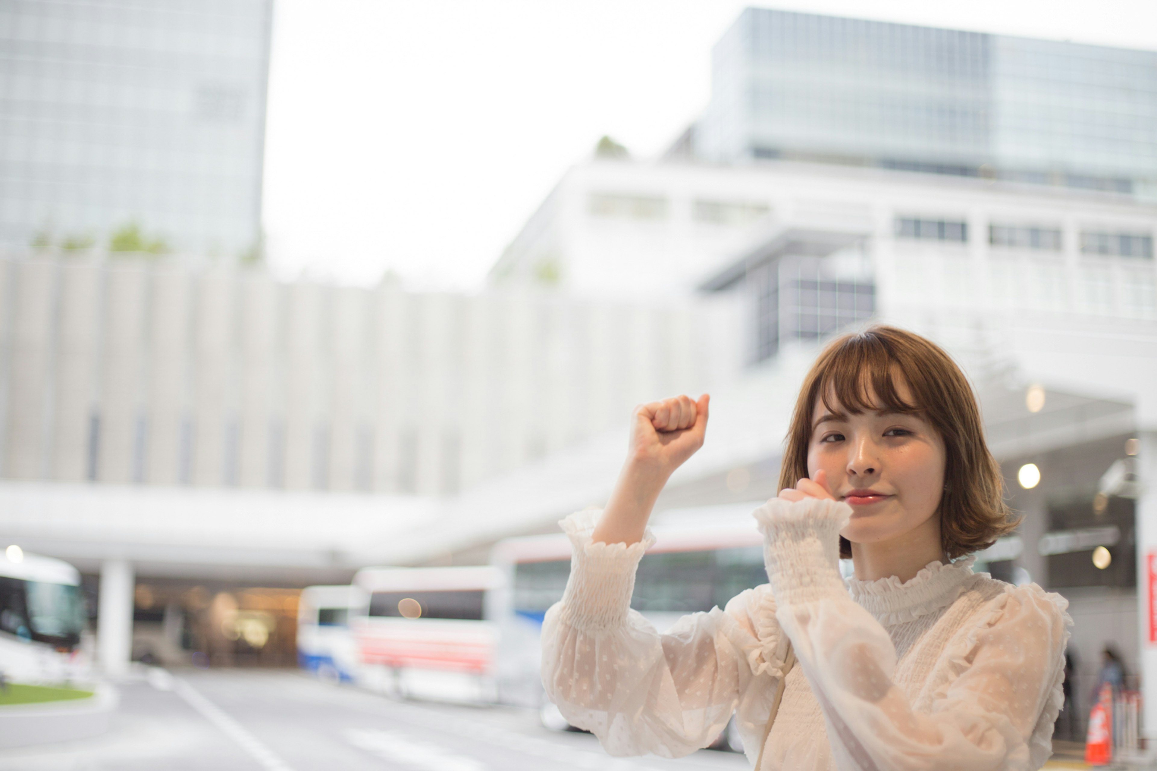 Une femme faisant un geste de victoire dans un cadre urbain