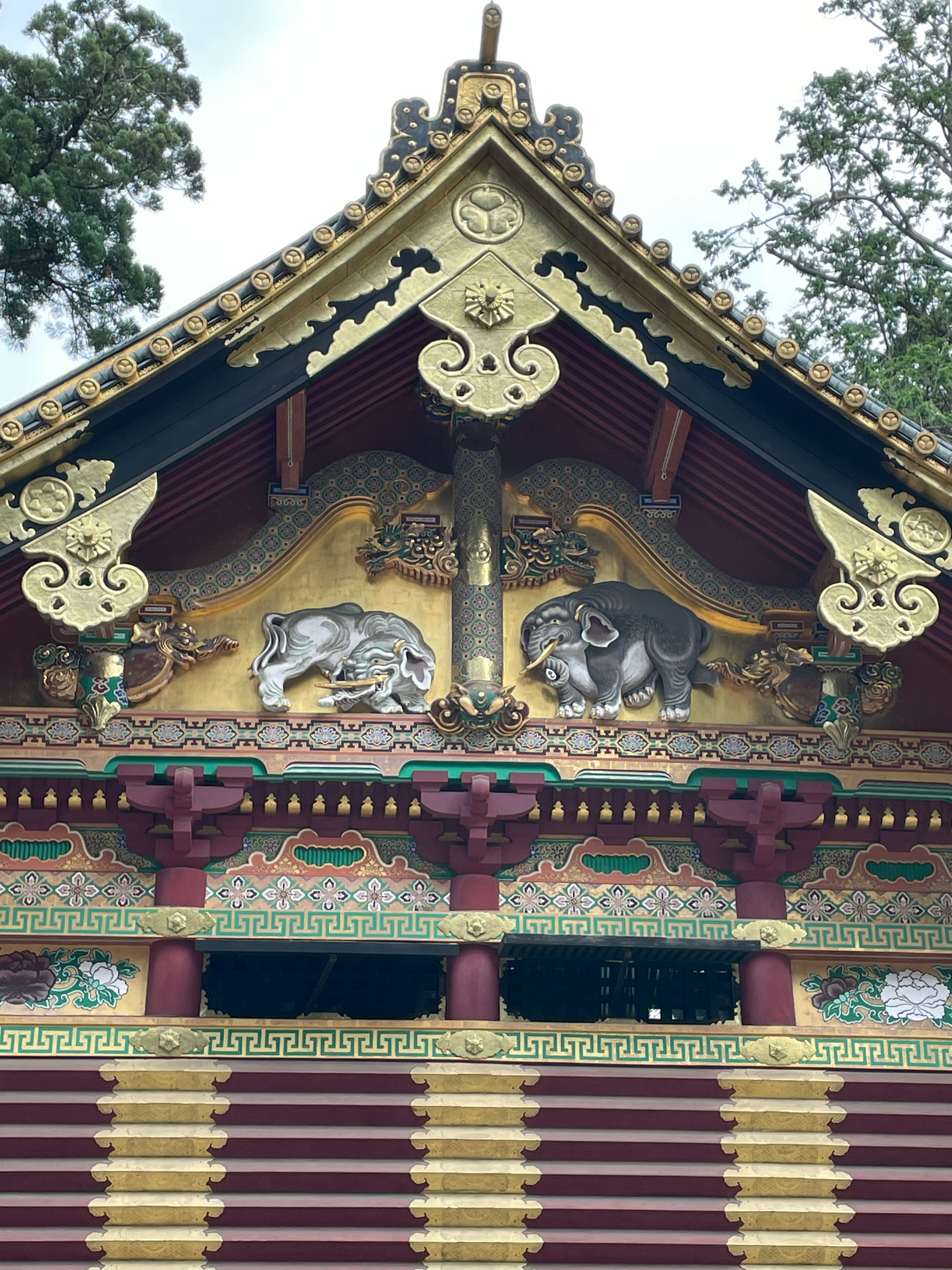 金色の細工と色彩豊かな動物の彫刻が施された神社の屋根