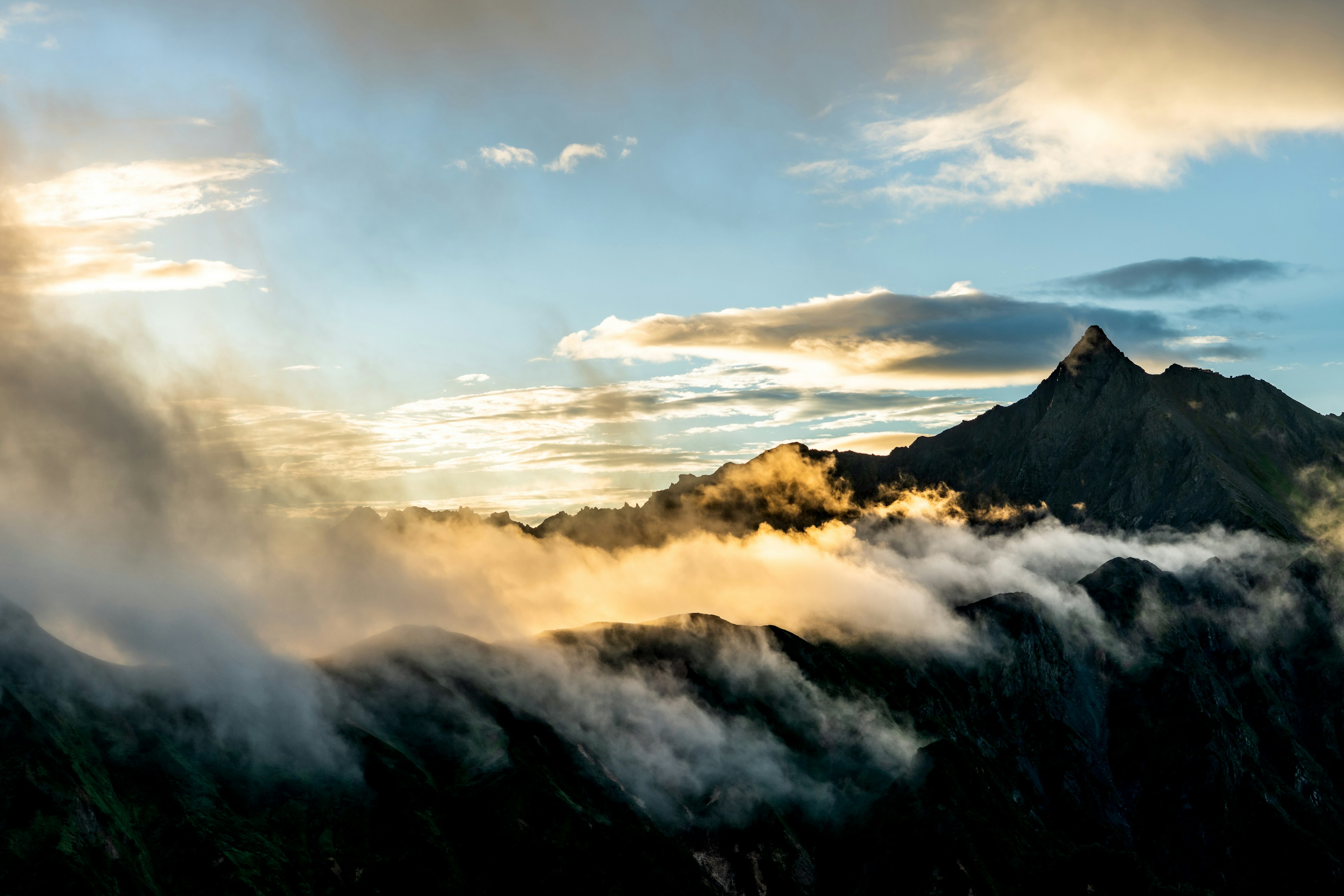 Mountain landscape at dusk with mist and clouds