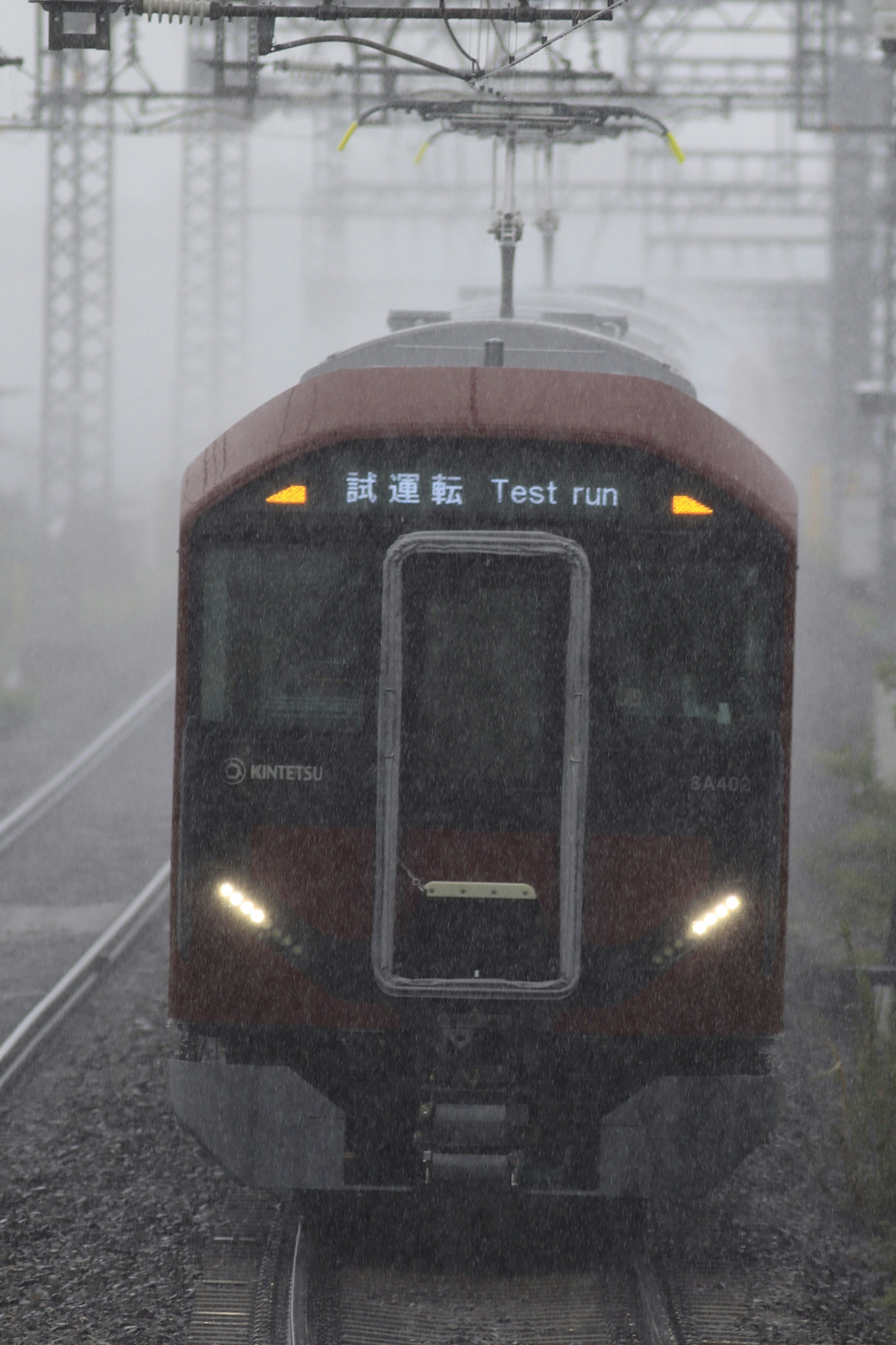 Red train running in the rain during test run