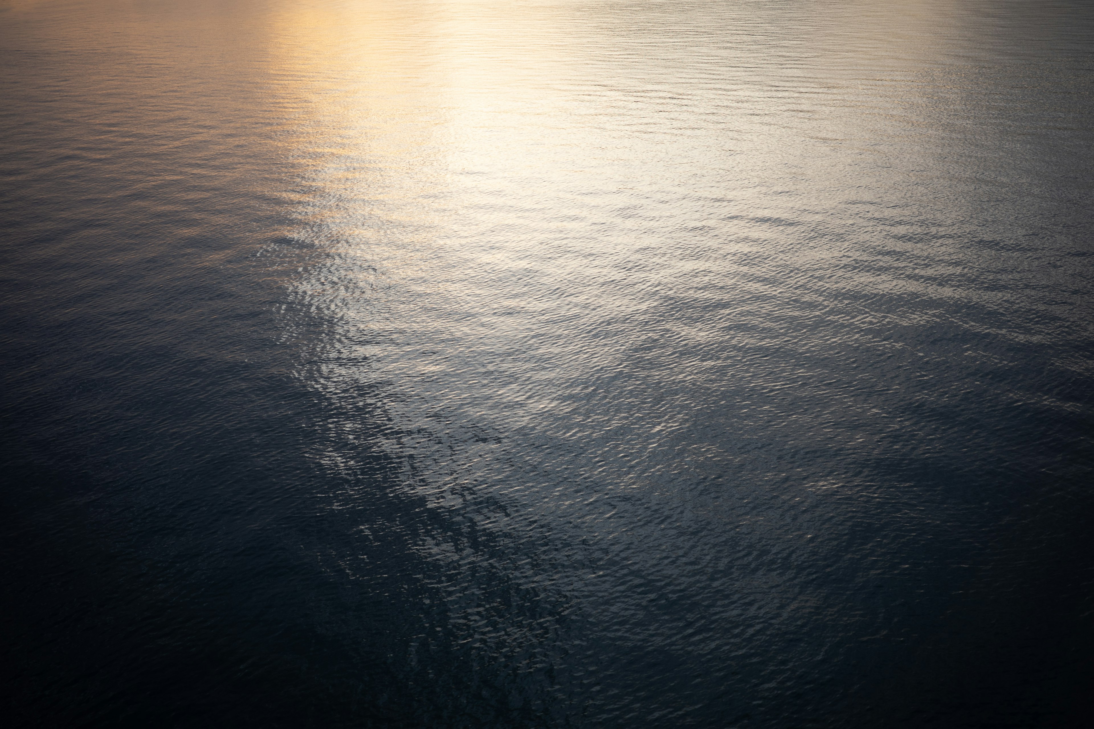 Ruhige Wasseroberfläche, die sanftes Licht reflektiert