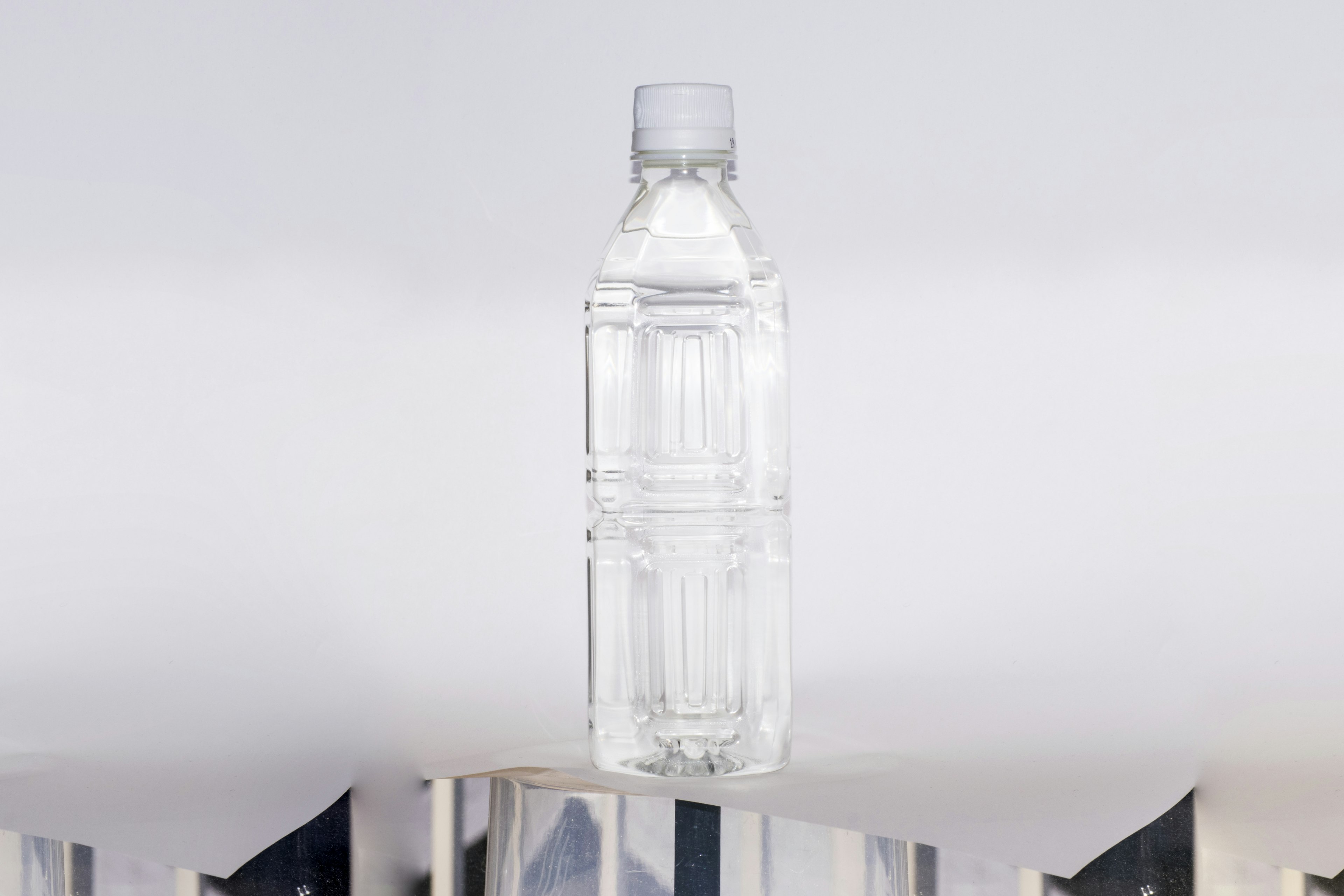 Clear water bottle placed on a transparent stand