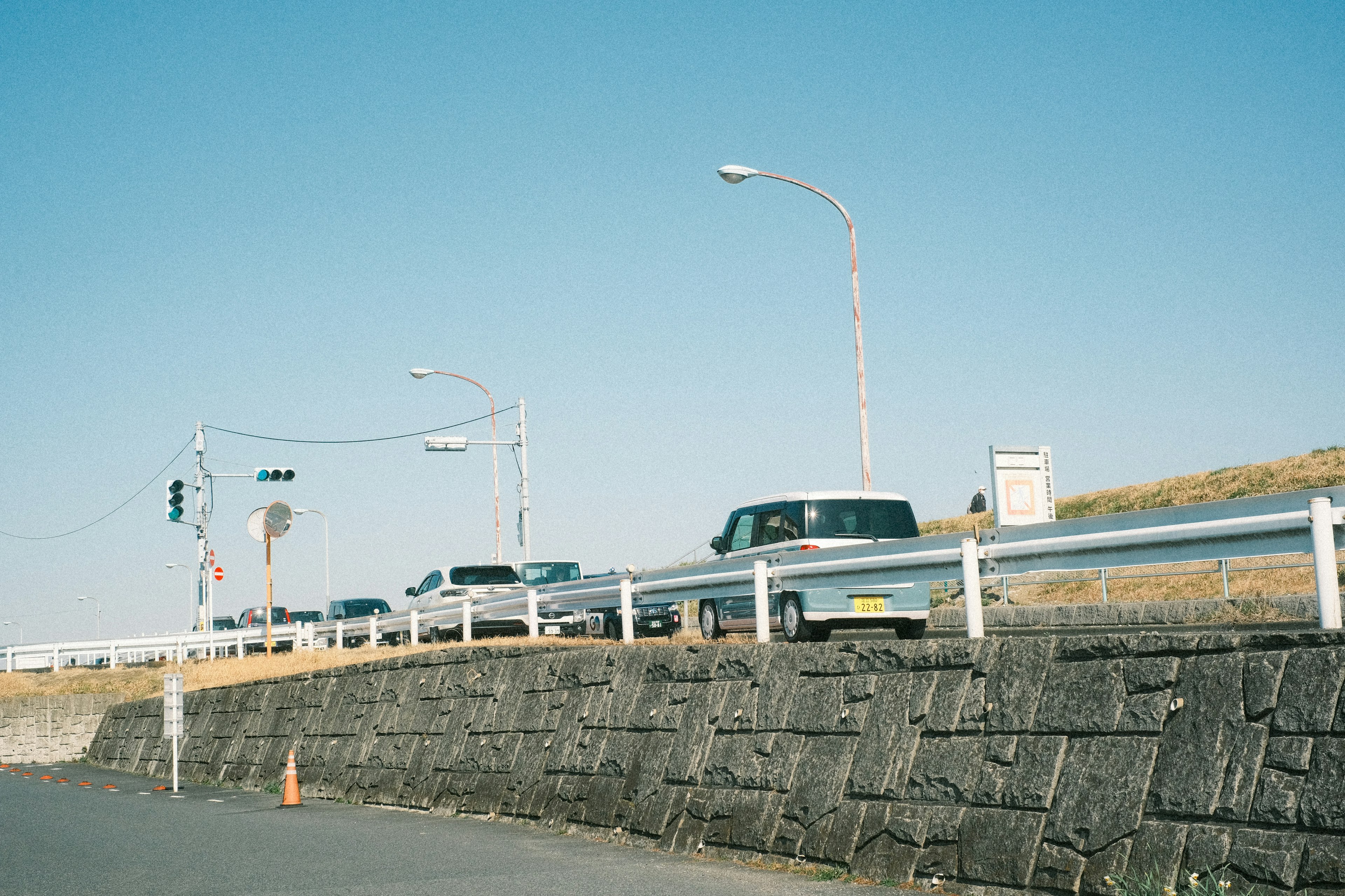 青空の下での車の列と交通信号の景色