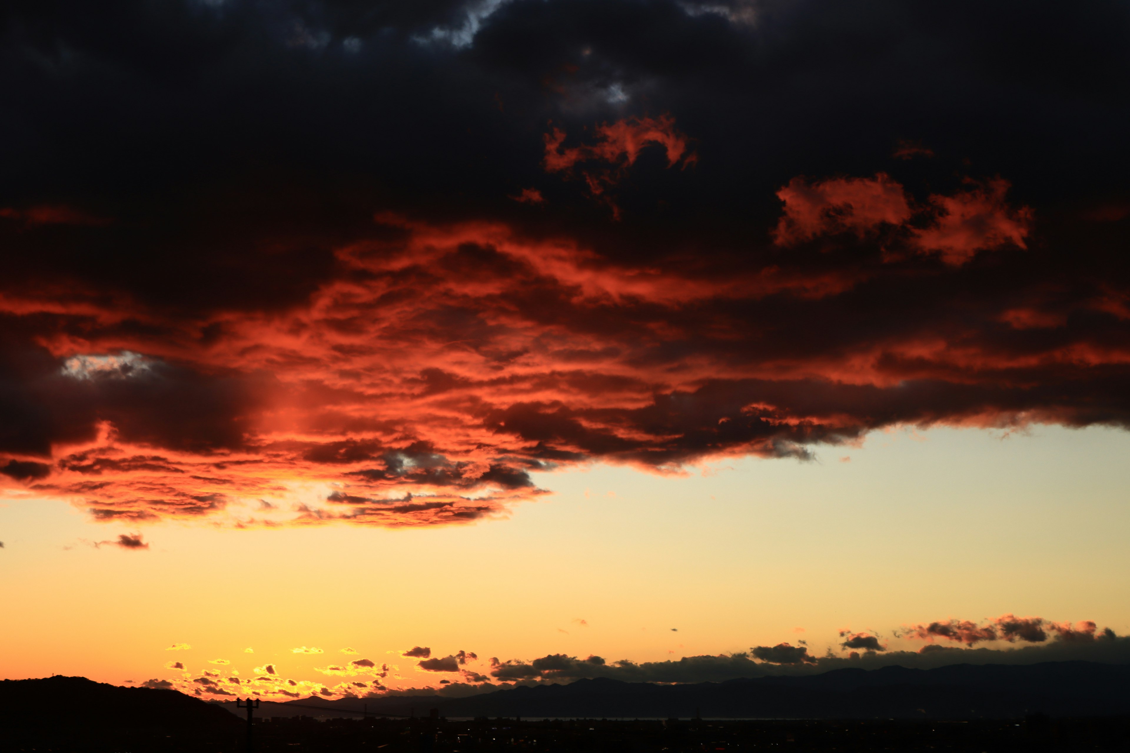 Cielo al tramonto con nuvole rosse e formazioni scure