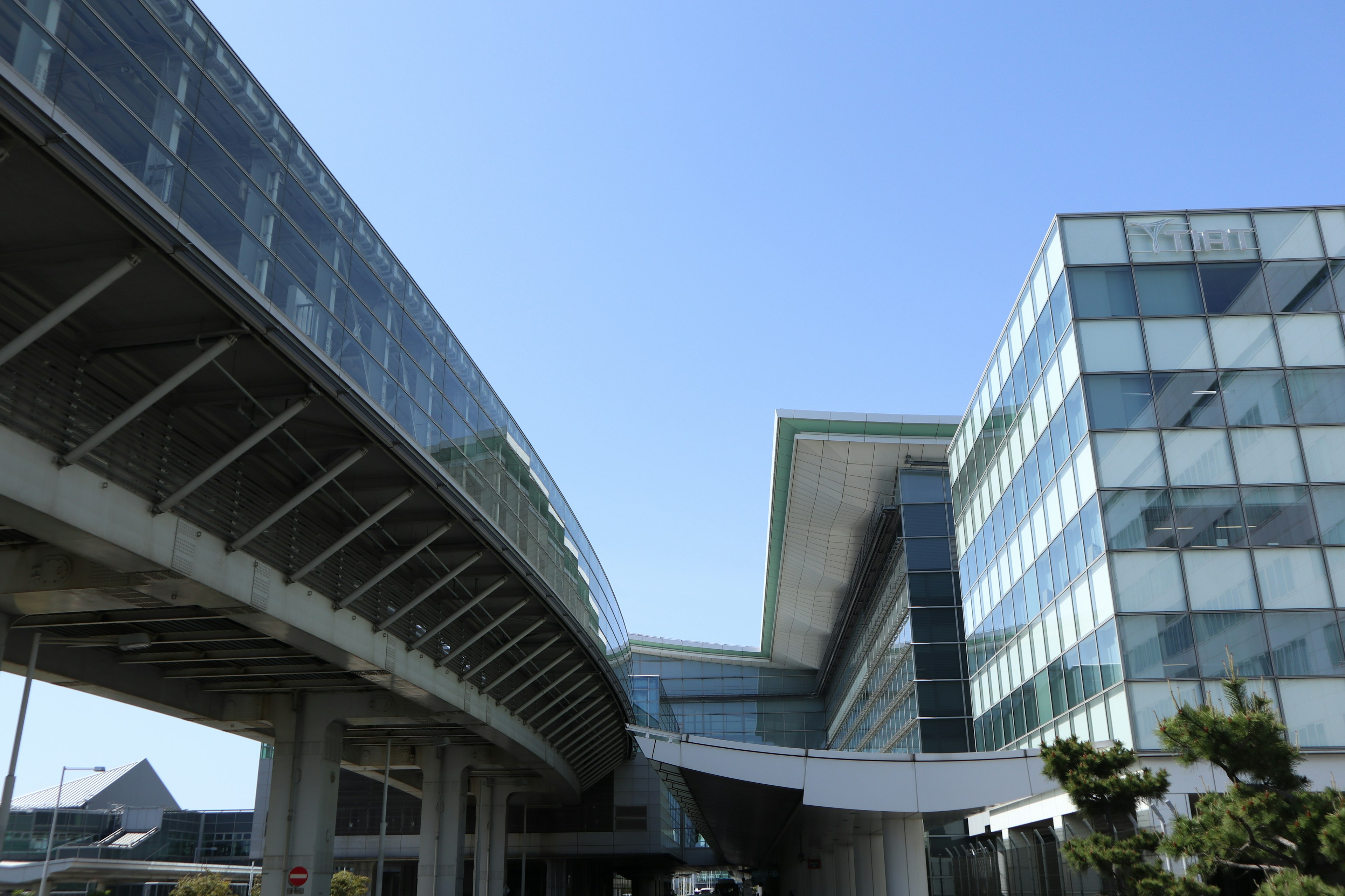 Bâtiment moderne avec structure en verre sous un ciel bleu