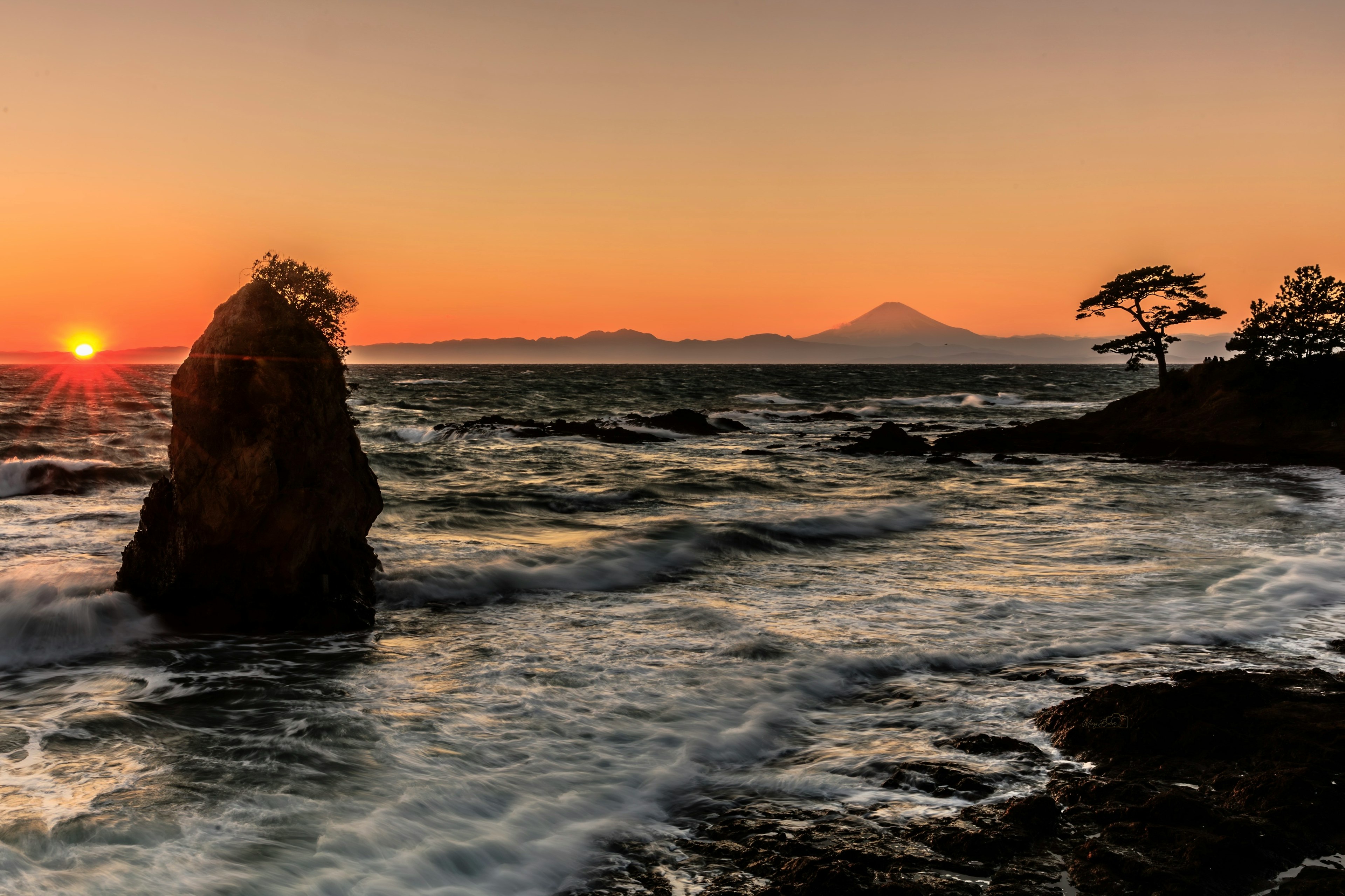 夕日が海に沈む風景 岩と波の動き 富士山の遠景