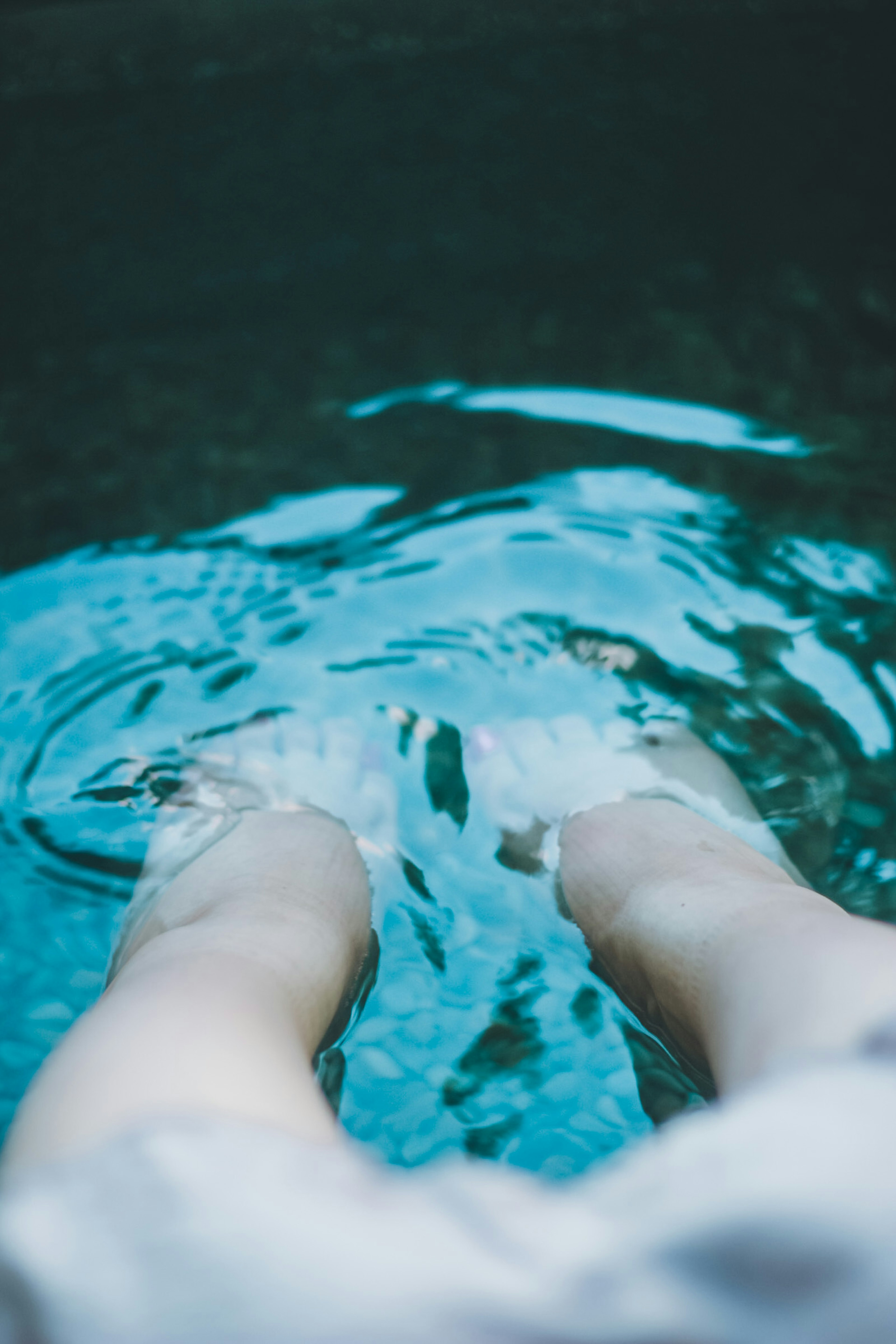 Feet submerged in clear water with ripples