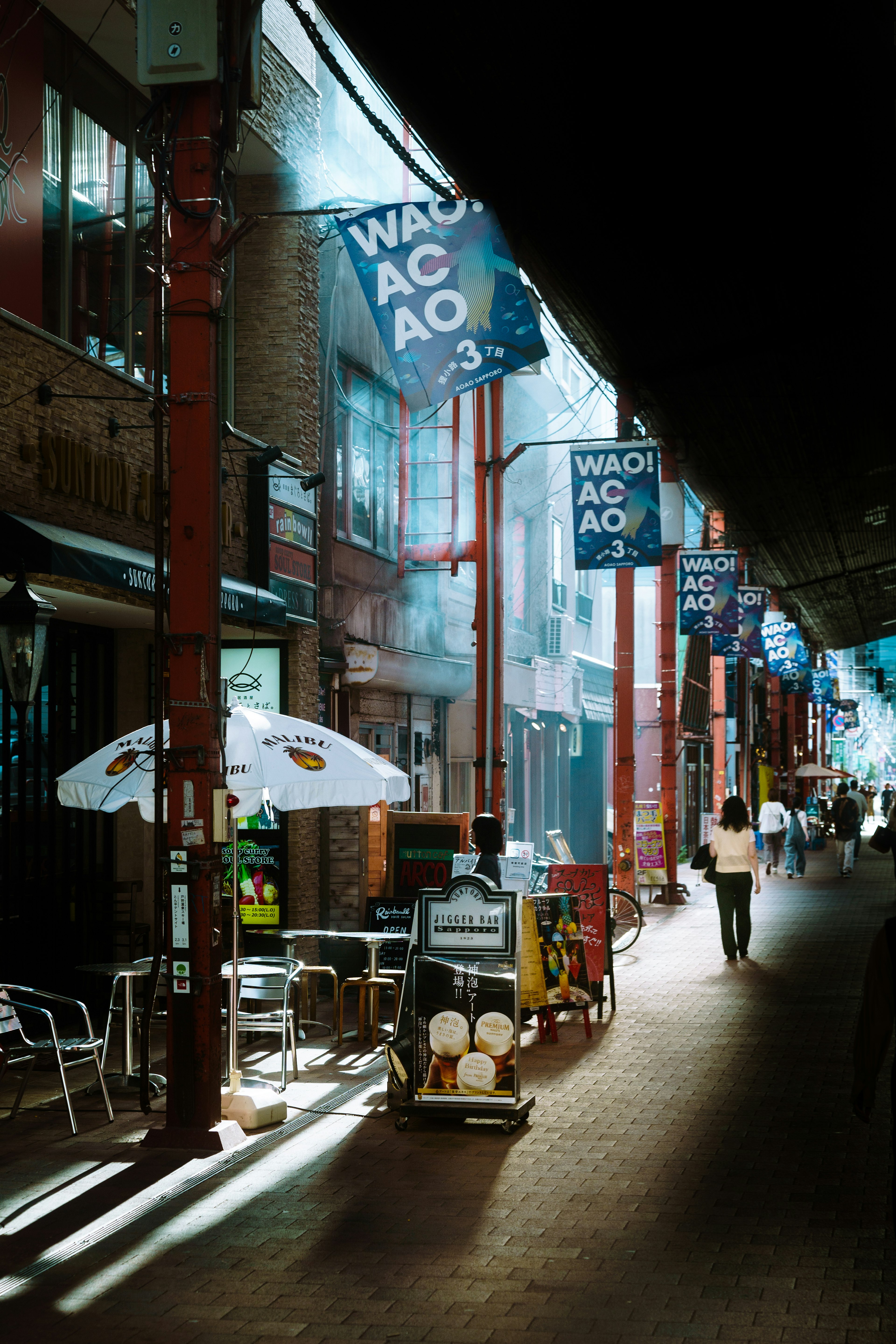 Nighttime street with blue flags and illuminated shops