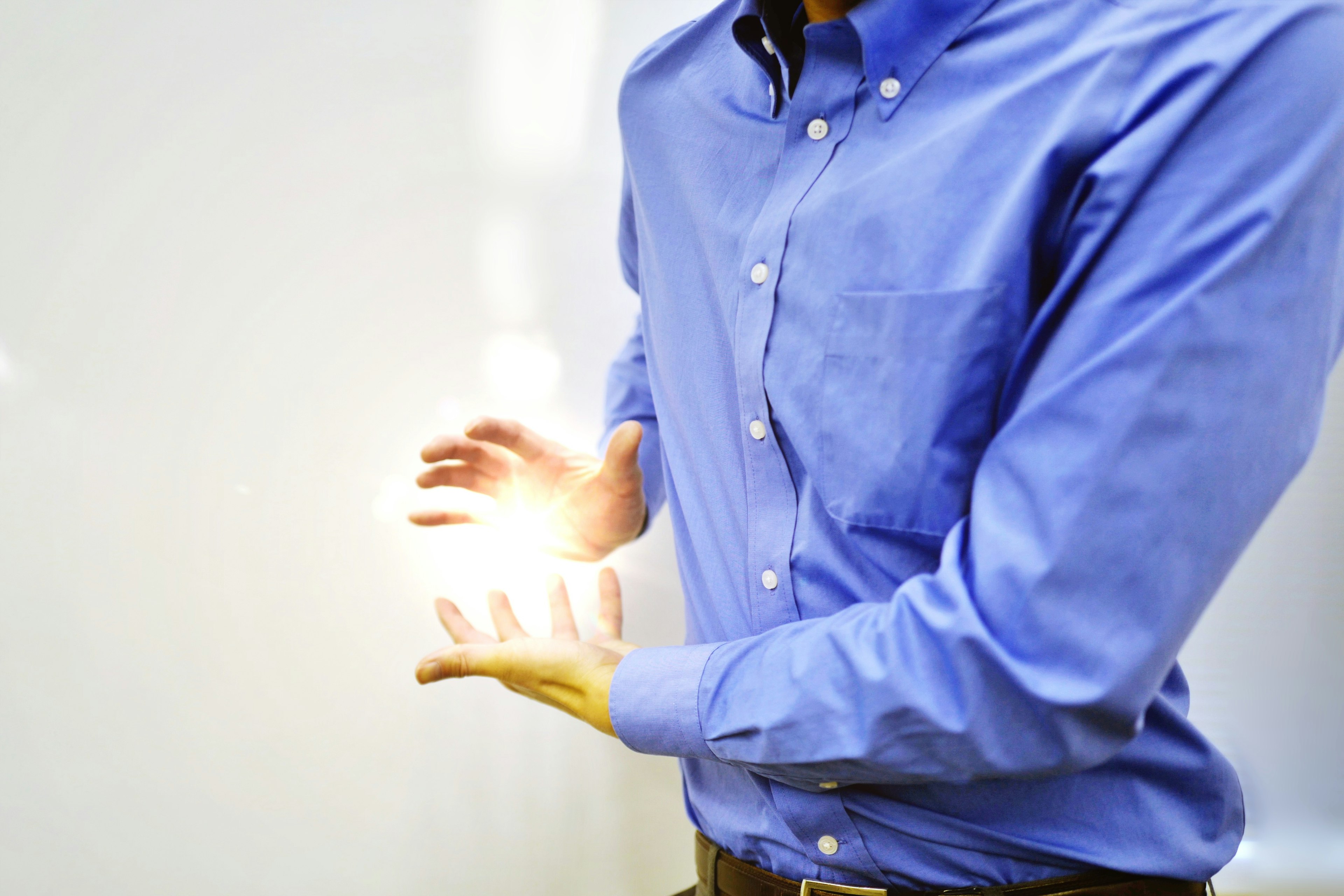 Uomo in camicia blu che tiene la luce tra le mani