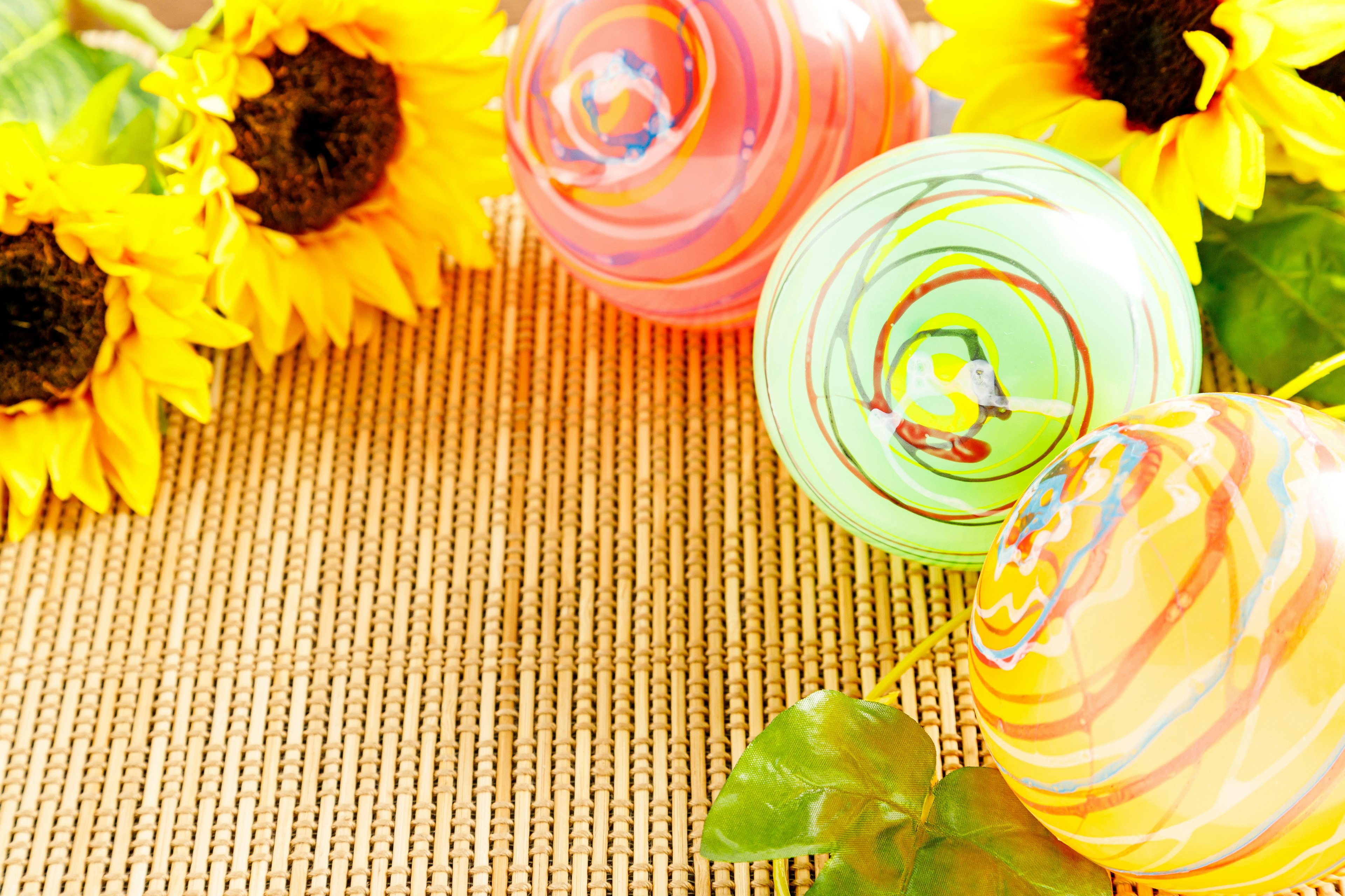 Sphères marbrées colorées à côté de tournesols sur une table décorative