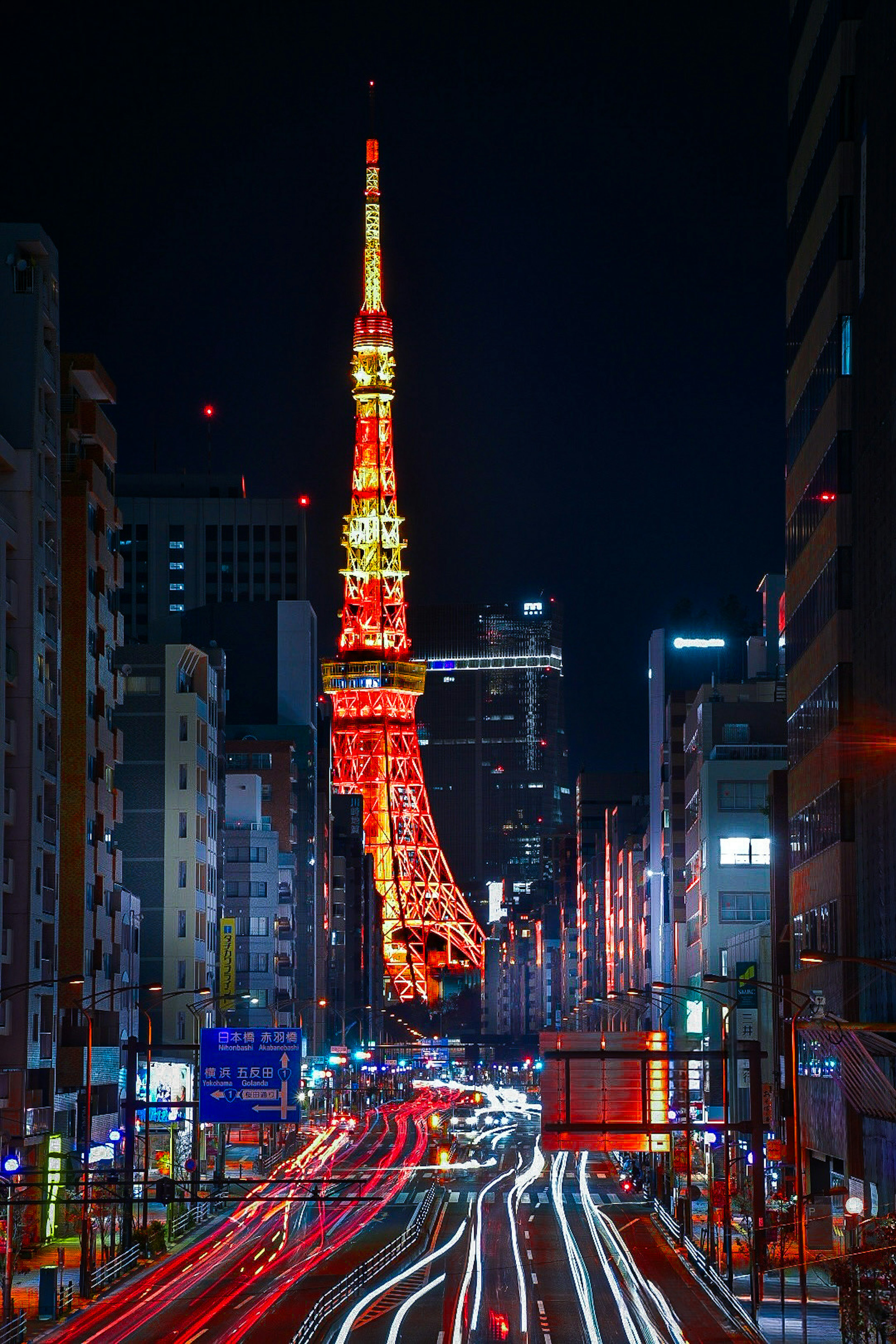 Menara Tokyo yang diterangi di malam hari dengan jejak cahaya dari mobil yang lewat