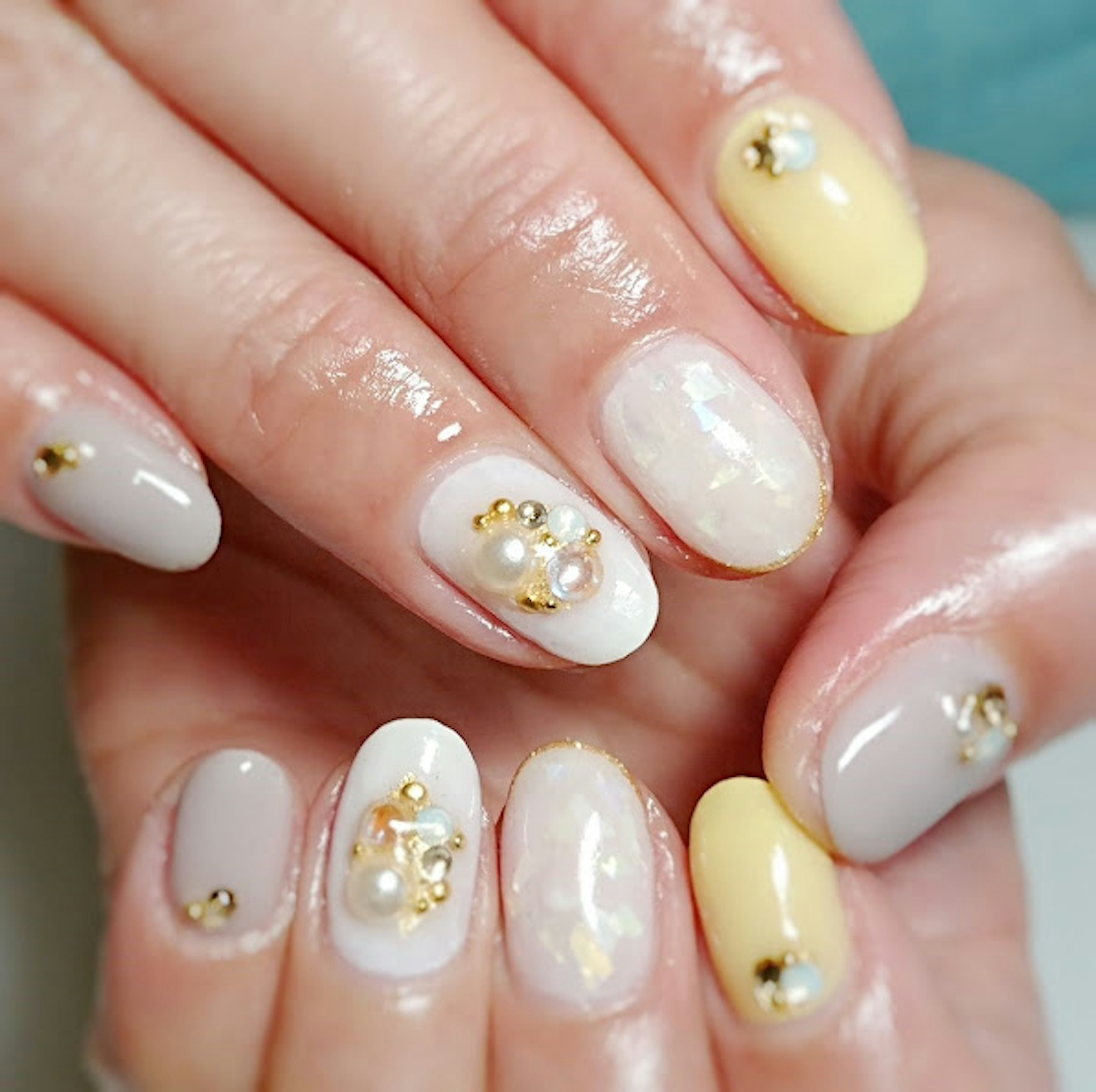 Close-up of beautifully designed nails featuring pastel colors and embellishments