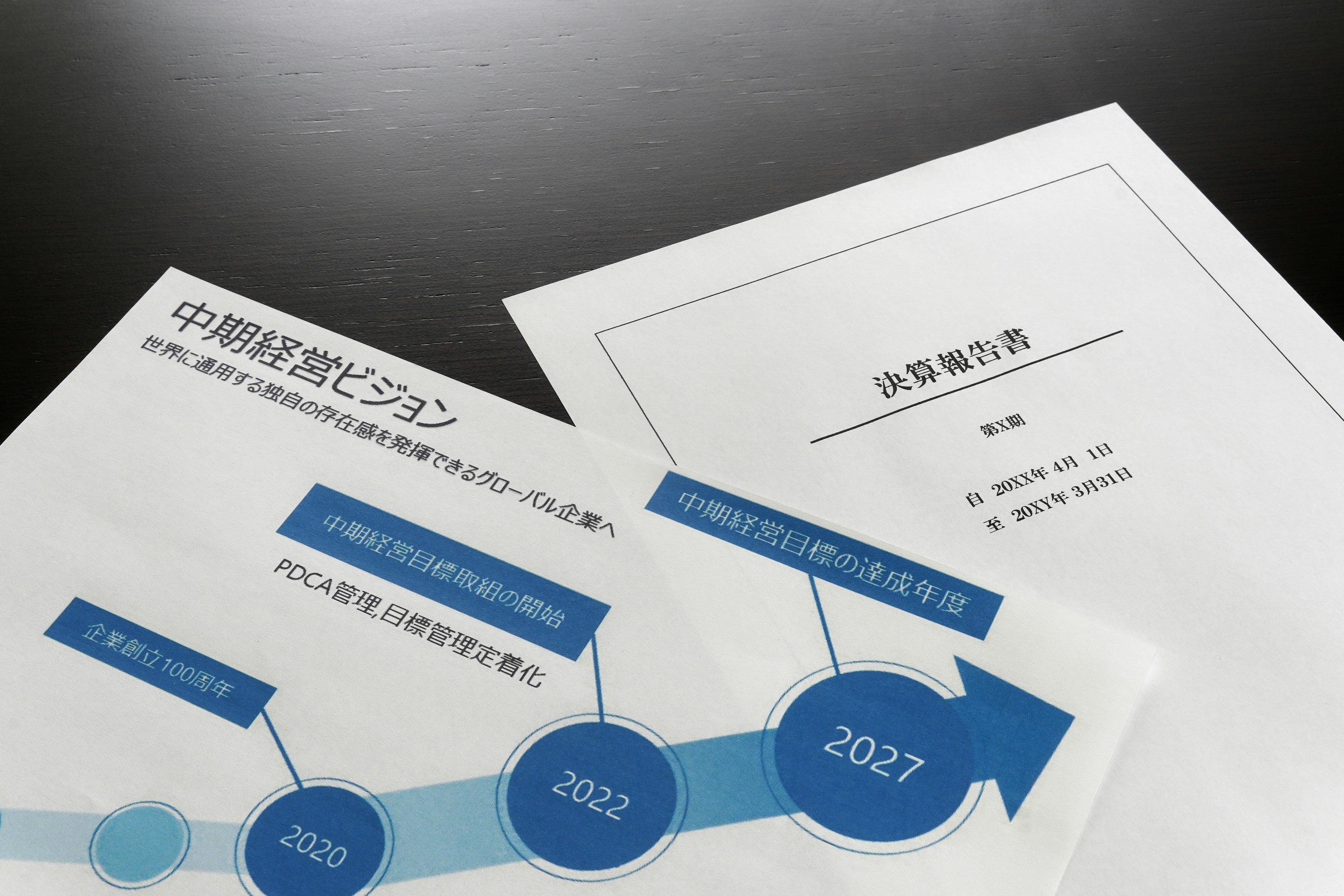 Documentos con un gráfico de línea de tiempo que muestra flechas azules y años sobre una mesa