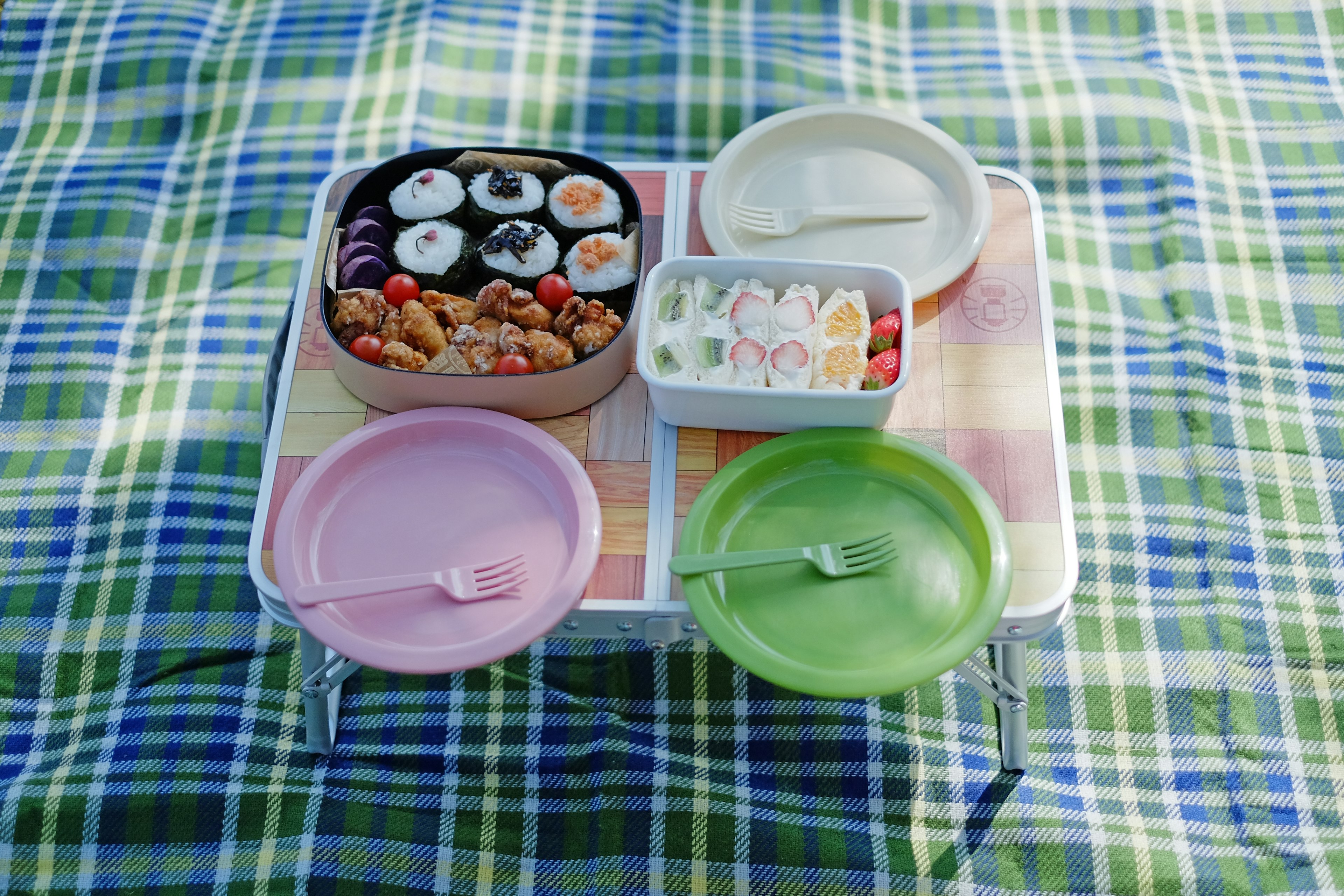 A table with assorted sushi and desserts arranged on it