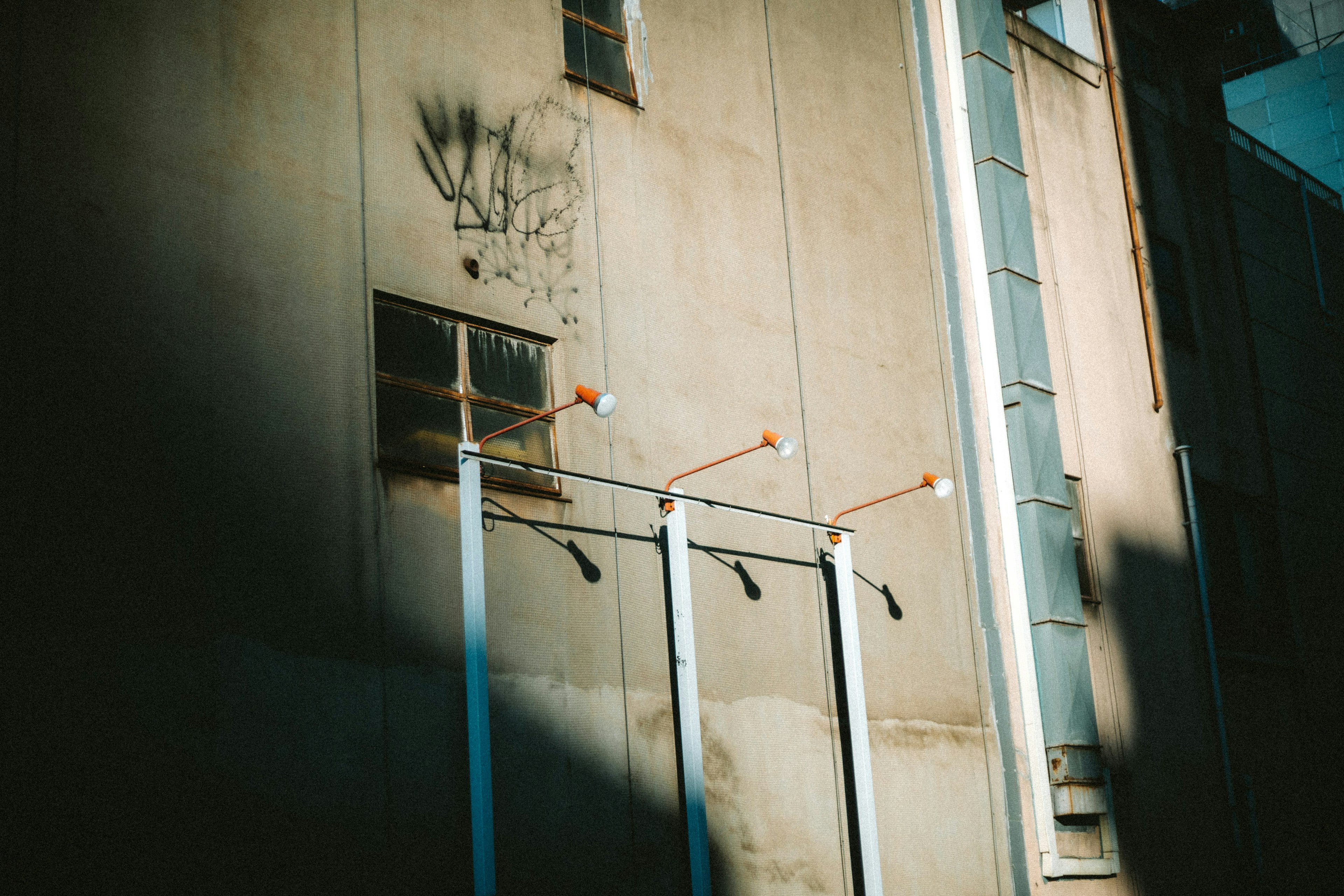 Tuberías blancas de pie contra una pared industrial con sombras