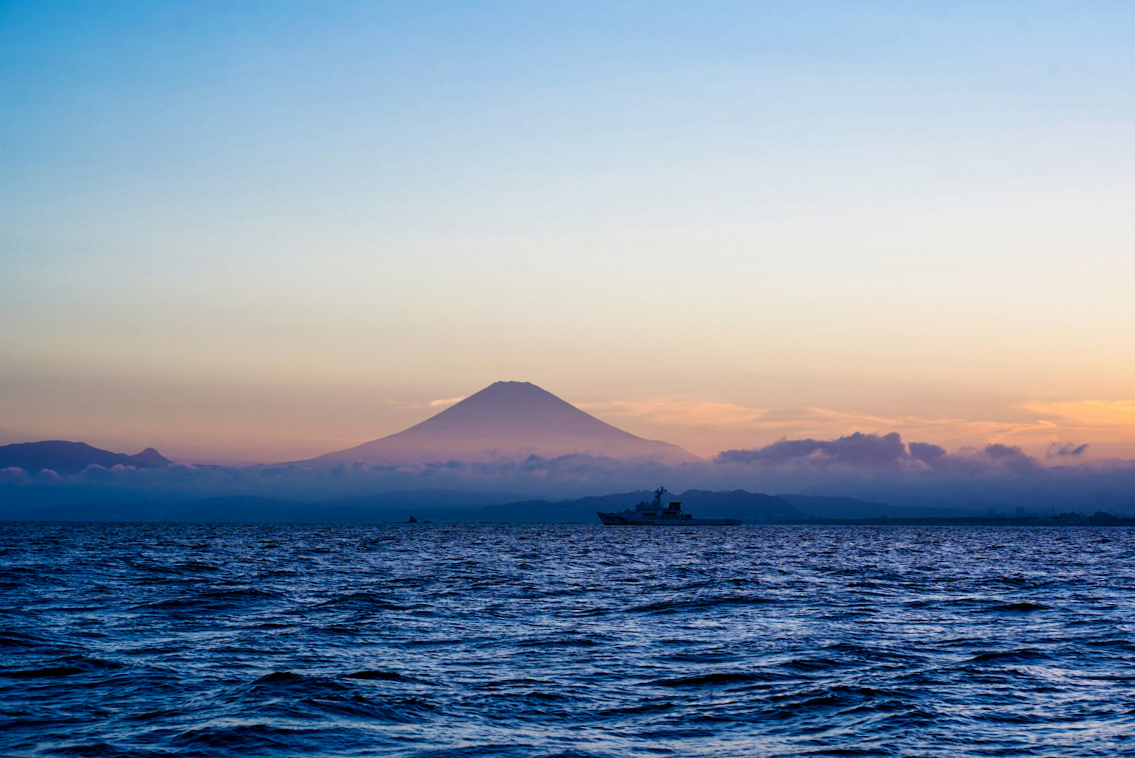 美しい富士山のシルエットが夕焼けに映える海の景色