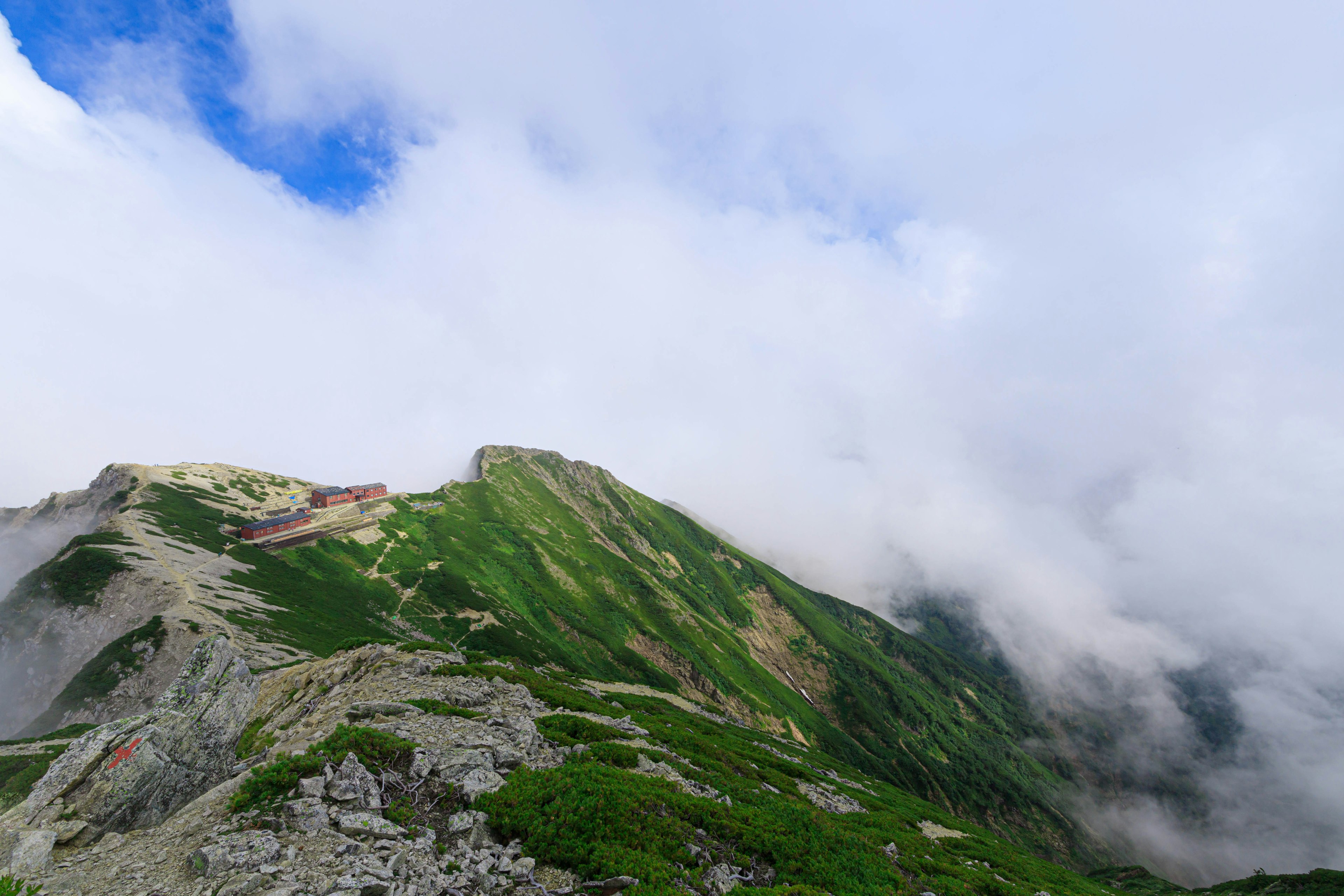 Scenic view of green mountains under cloudy skies