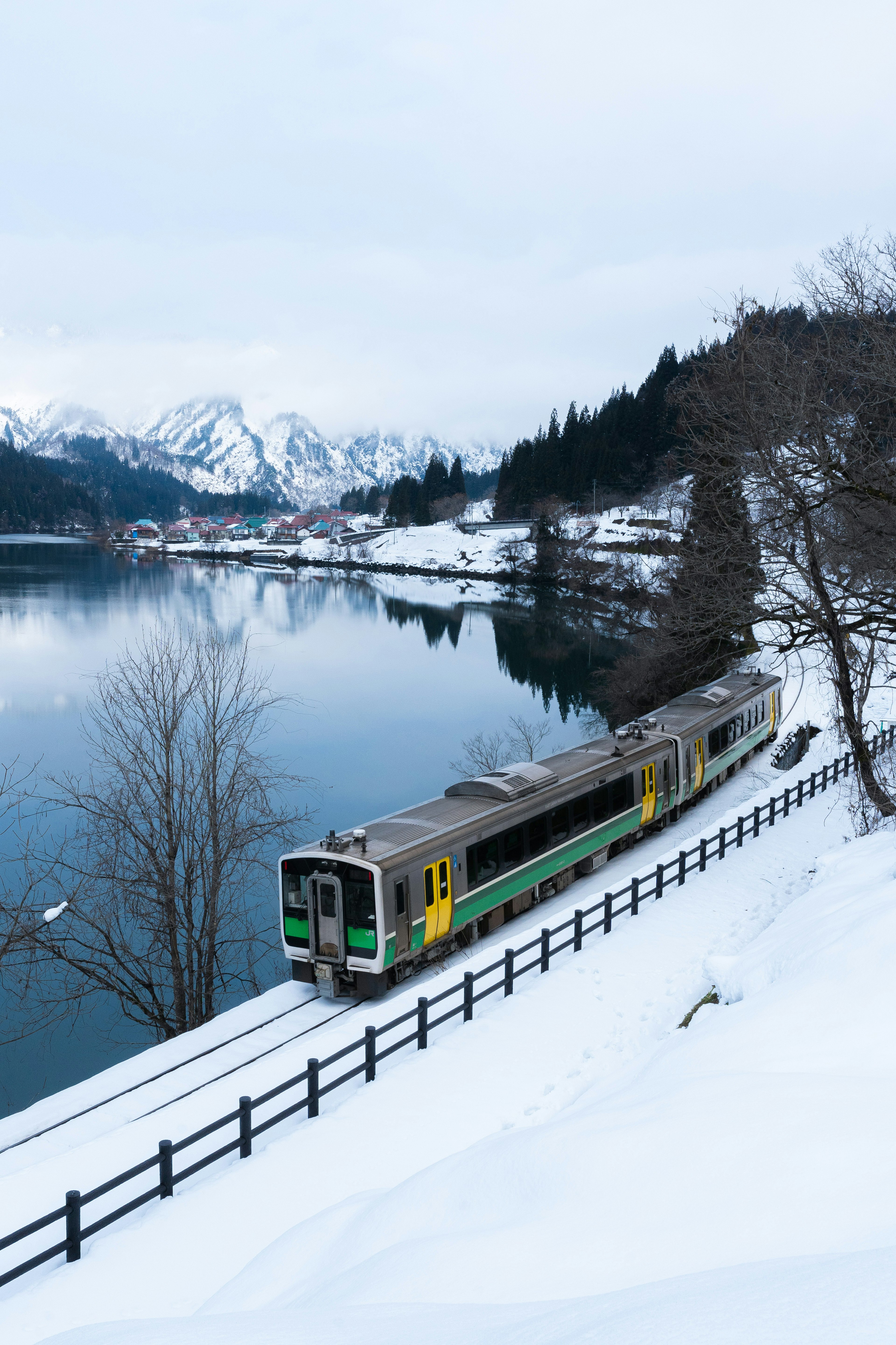 雪に覆われた風景を走る列車と静かな湖の美しい景色