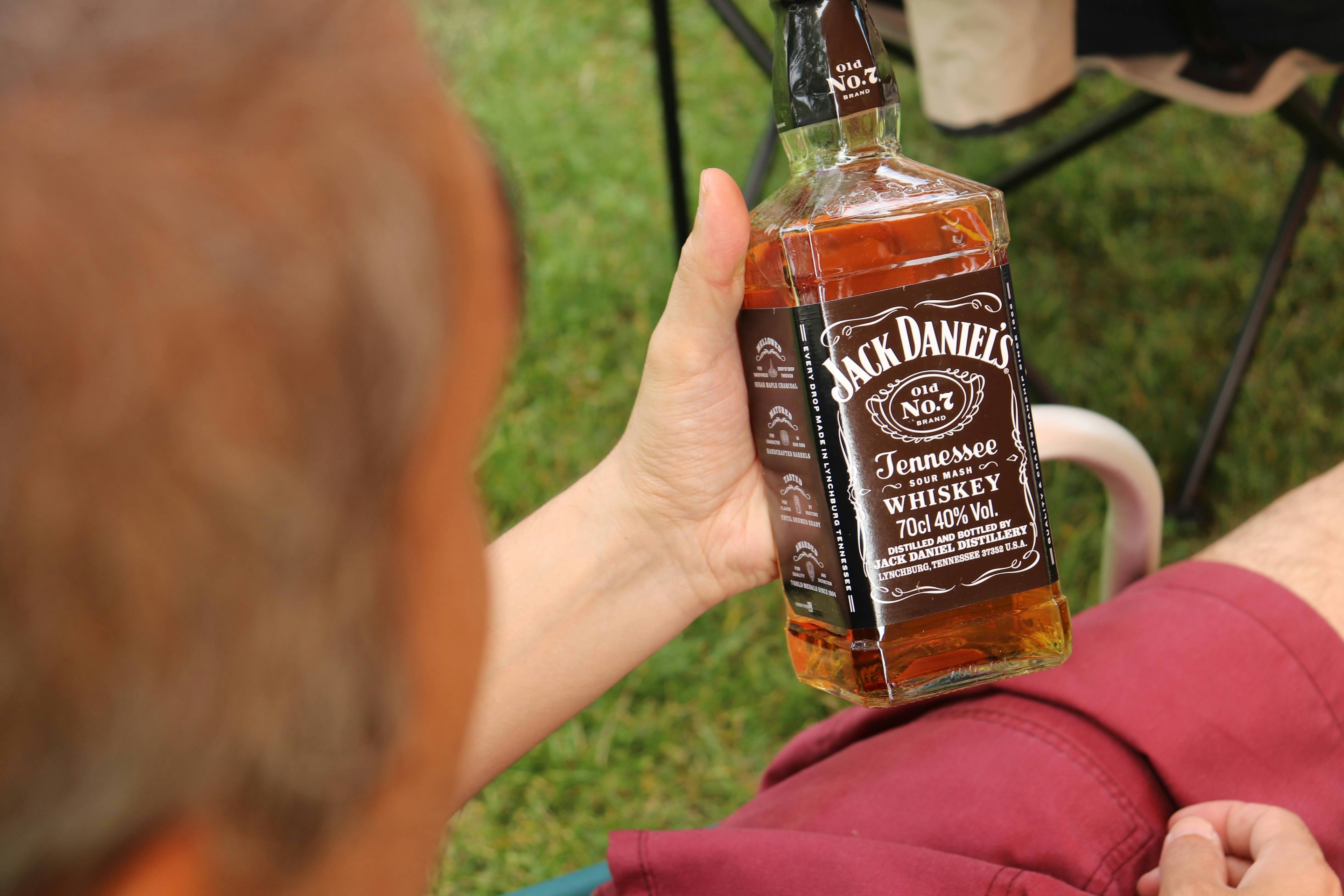 Pria memegang botol whiskey Jack Daniel's