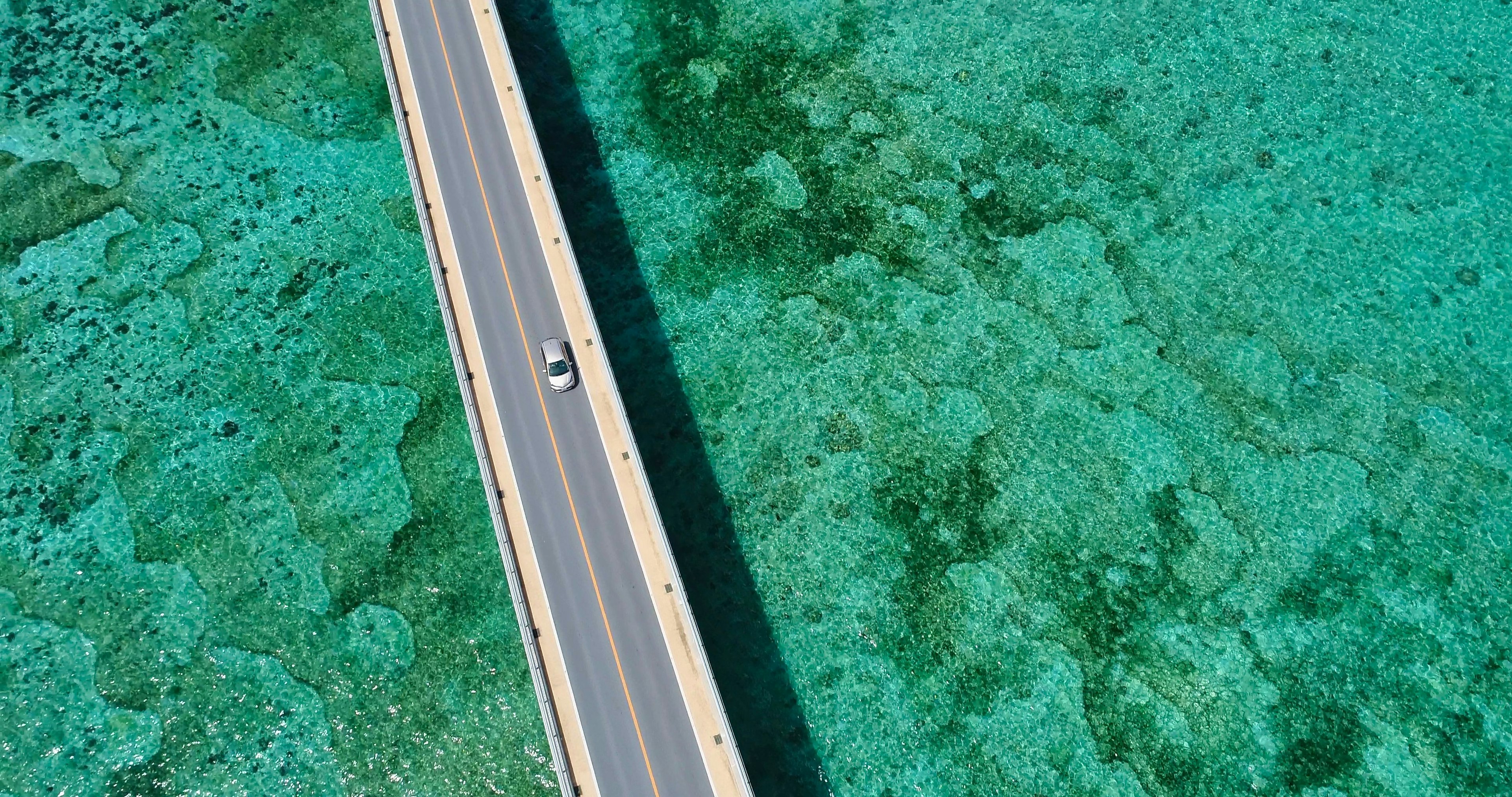 Aerial view of a road over turquoise water