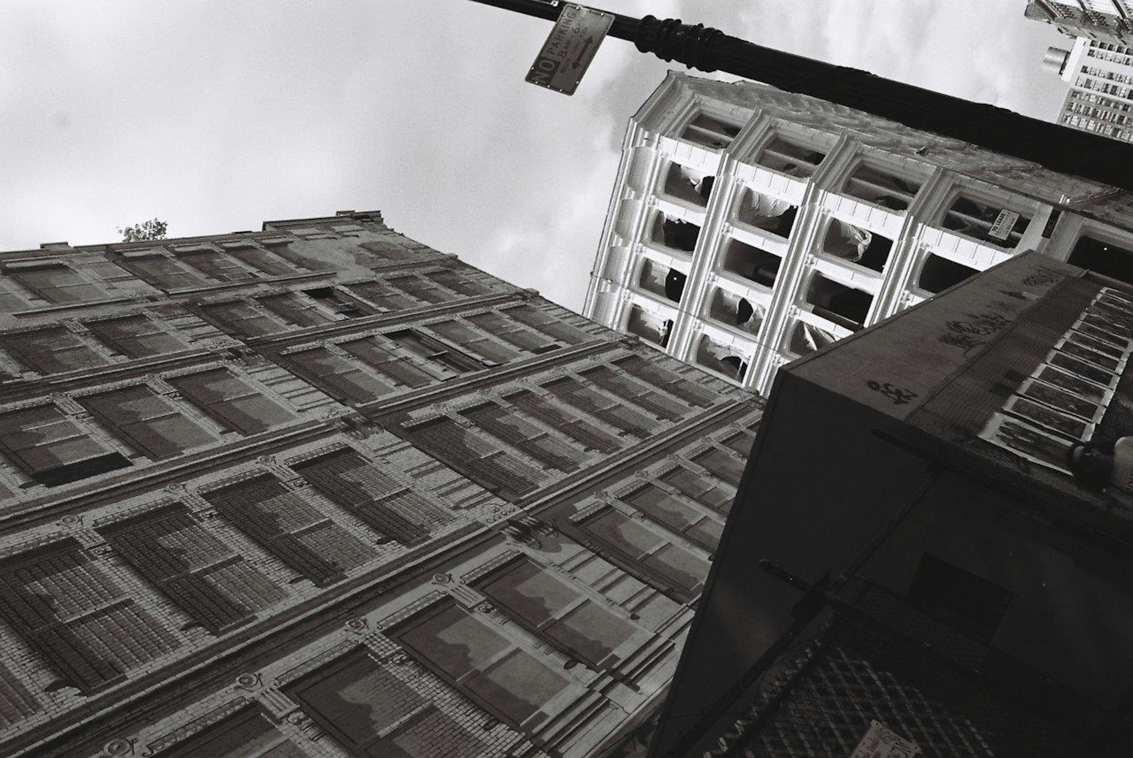 Paisaje urbano en blanco y negro con edificios inclinados y cielo