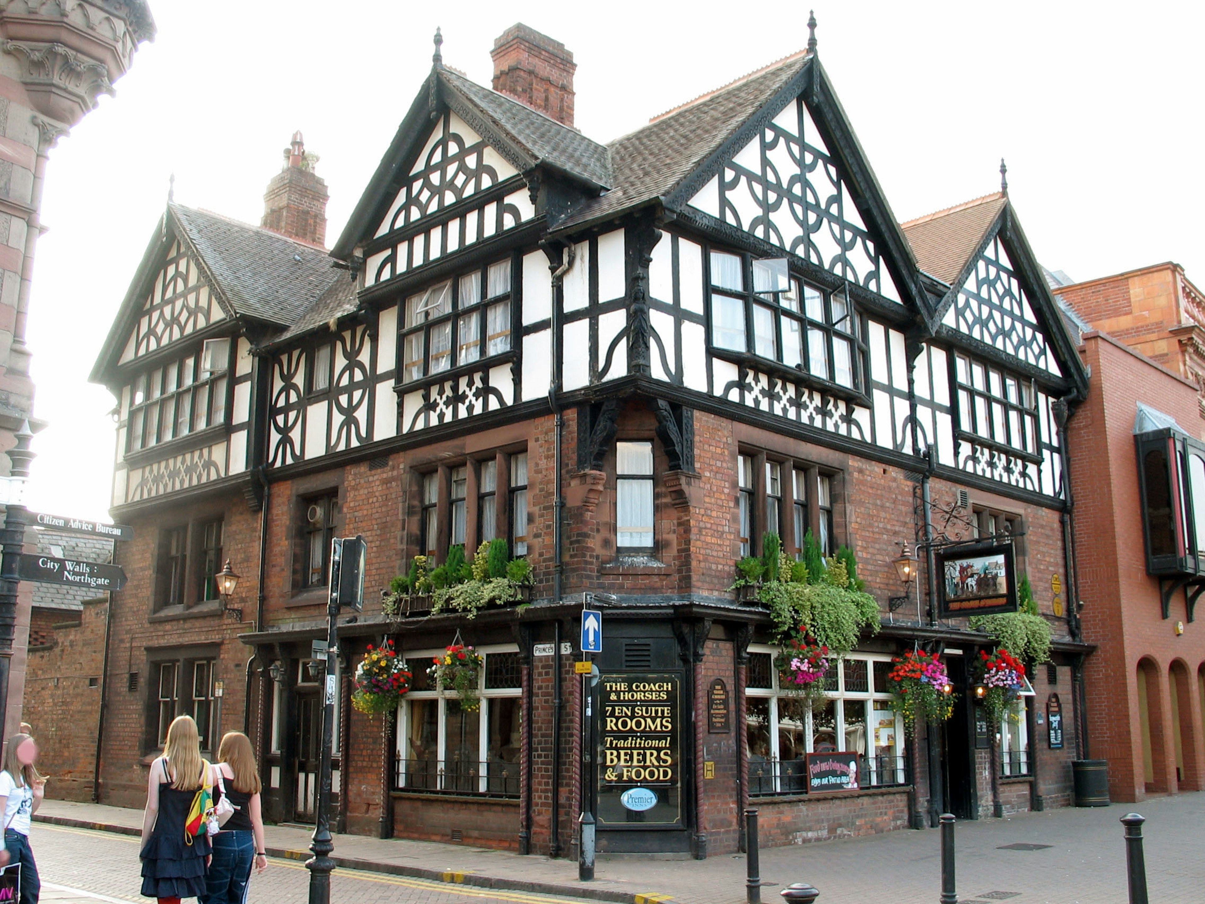 Historic building exterior with black and white timber framing and flower displays