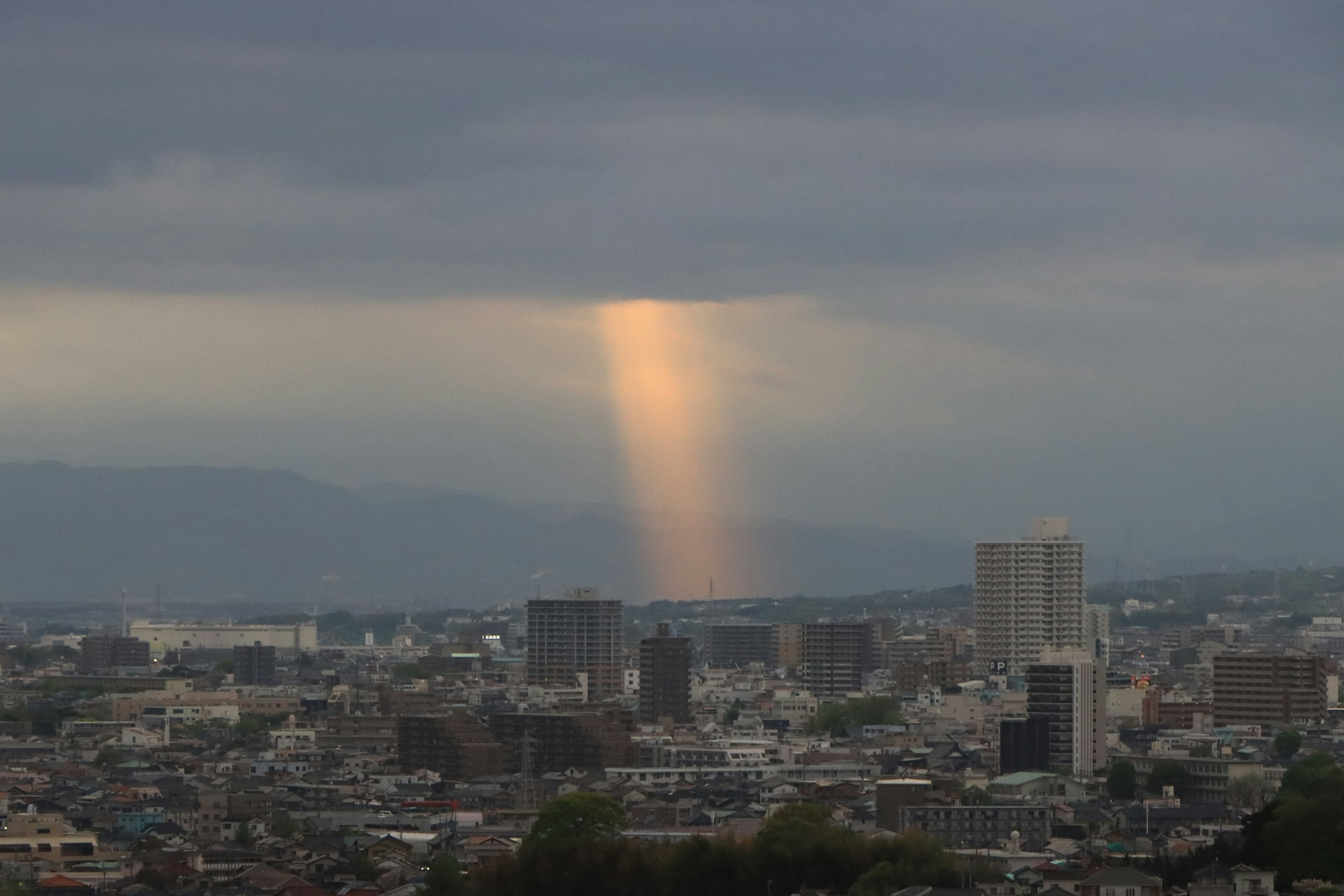 Cityscape with a beam of light shining through clouds