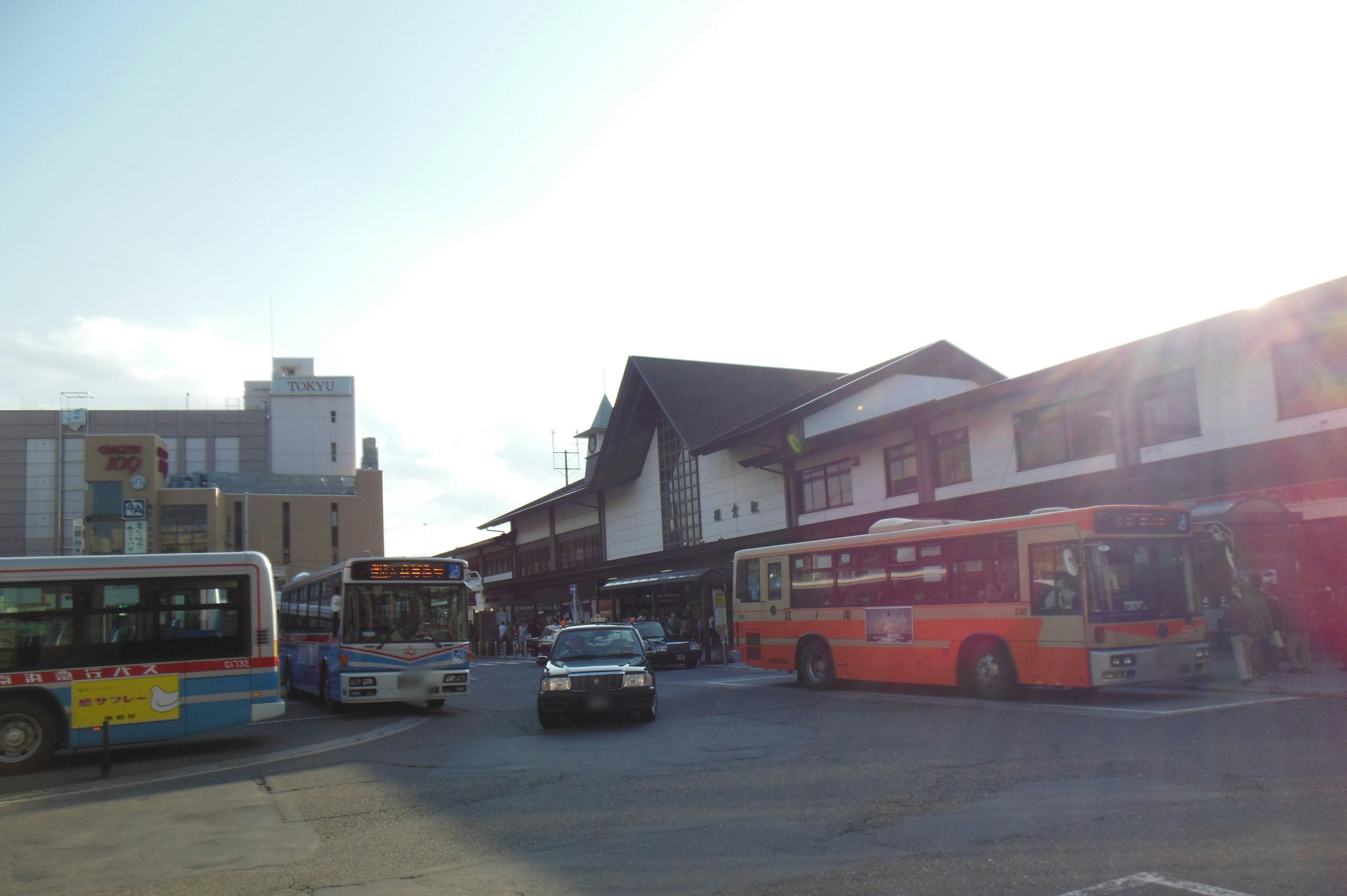 公交车站场景，周围建筑和可见的公交车