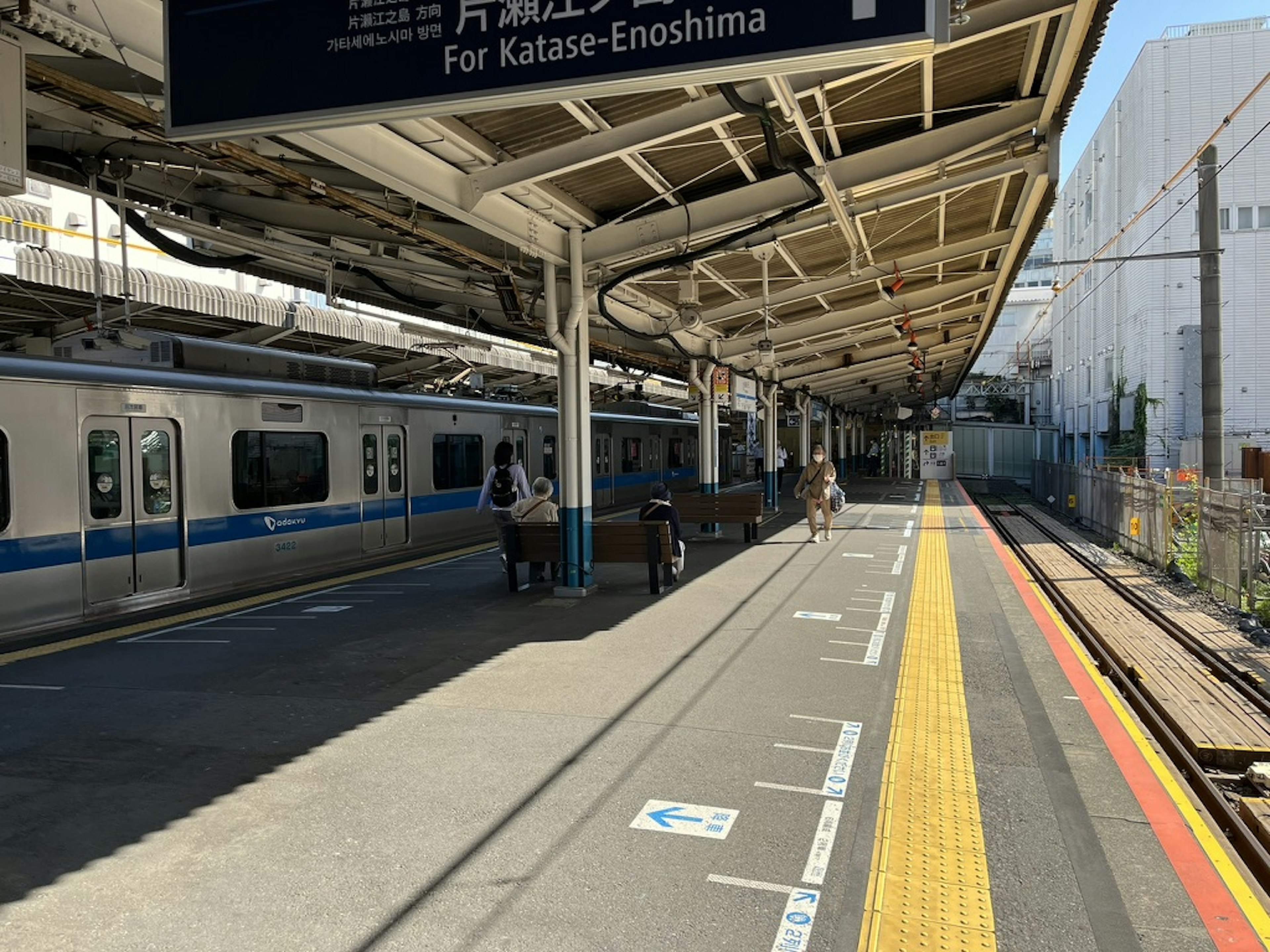 Plateforme d'une gare avec un train à destination de Katase-Enoshima