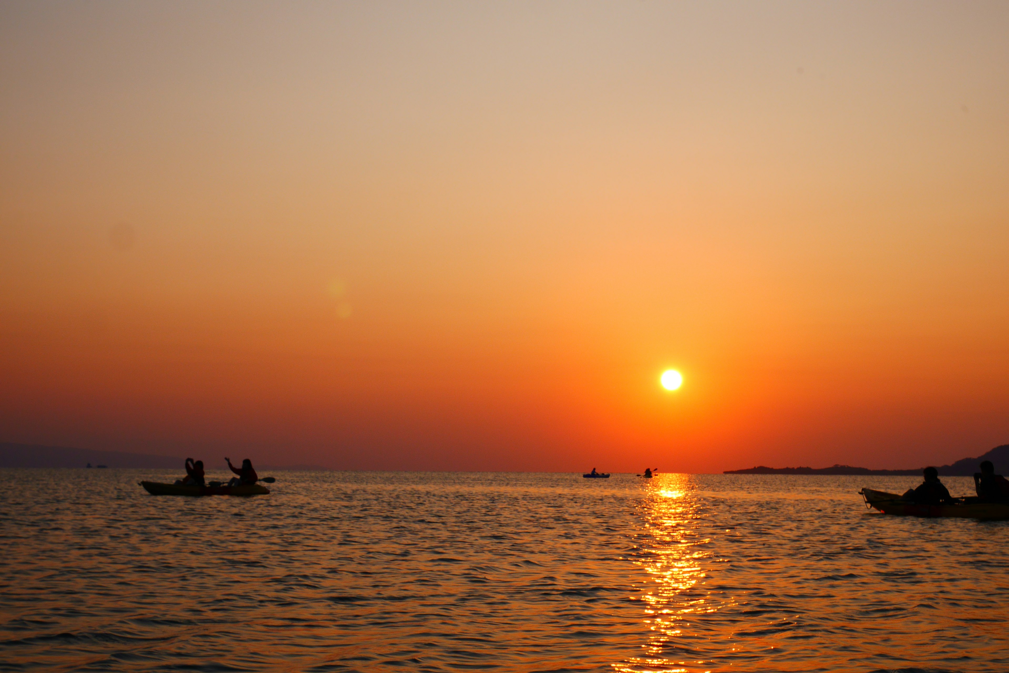 Schöner Sonnenuntergang, der sich auf dem Meer mit kleinen Booten spiegelt