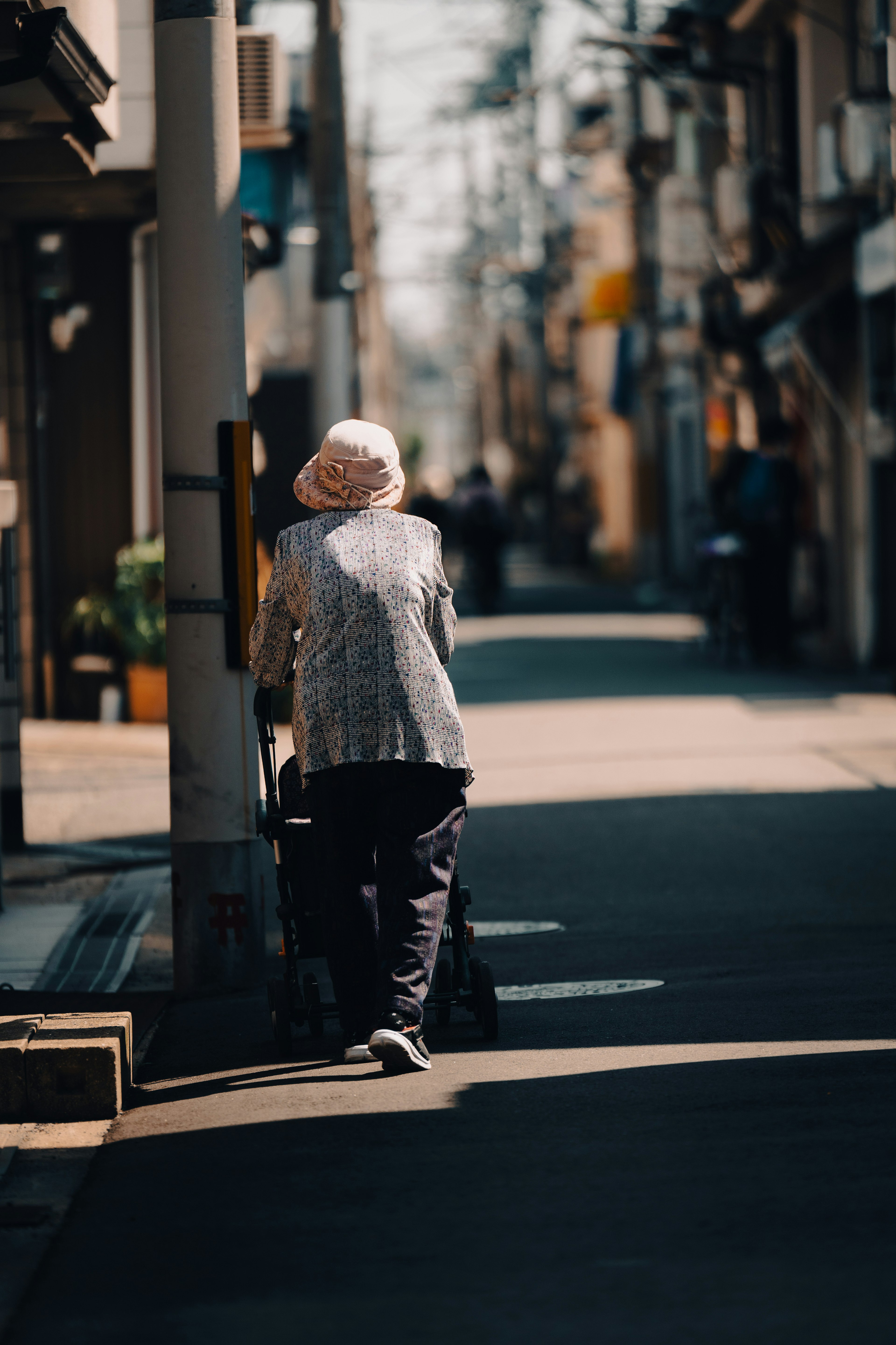 Elderly person walking down a quiet street