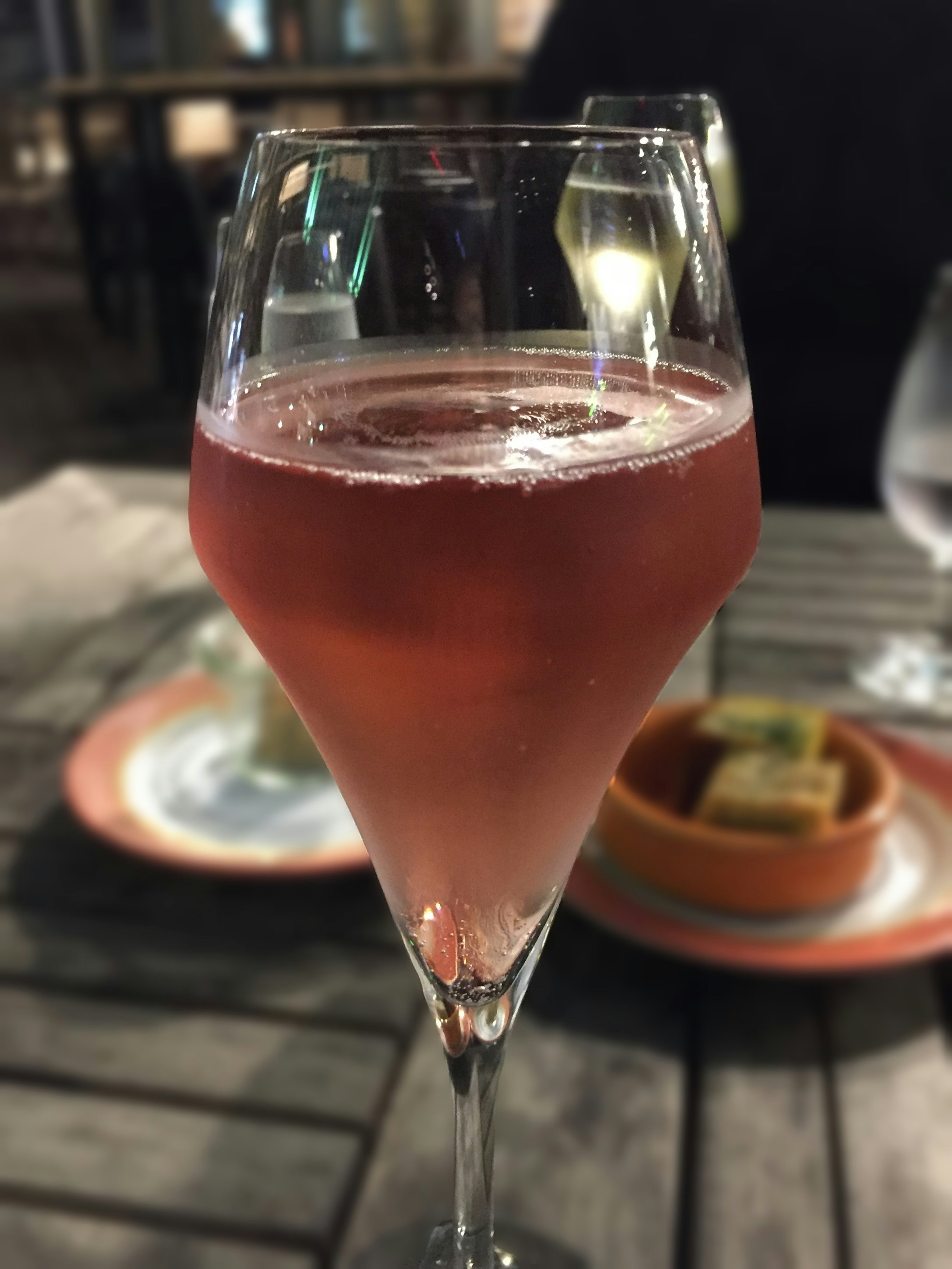 Ein Glas mit einem rosa Getränk auf einem Holztisch