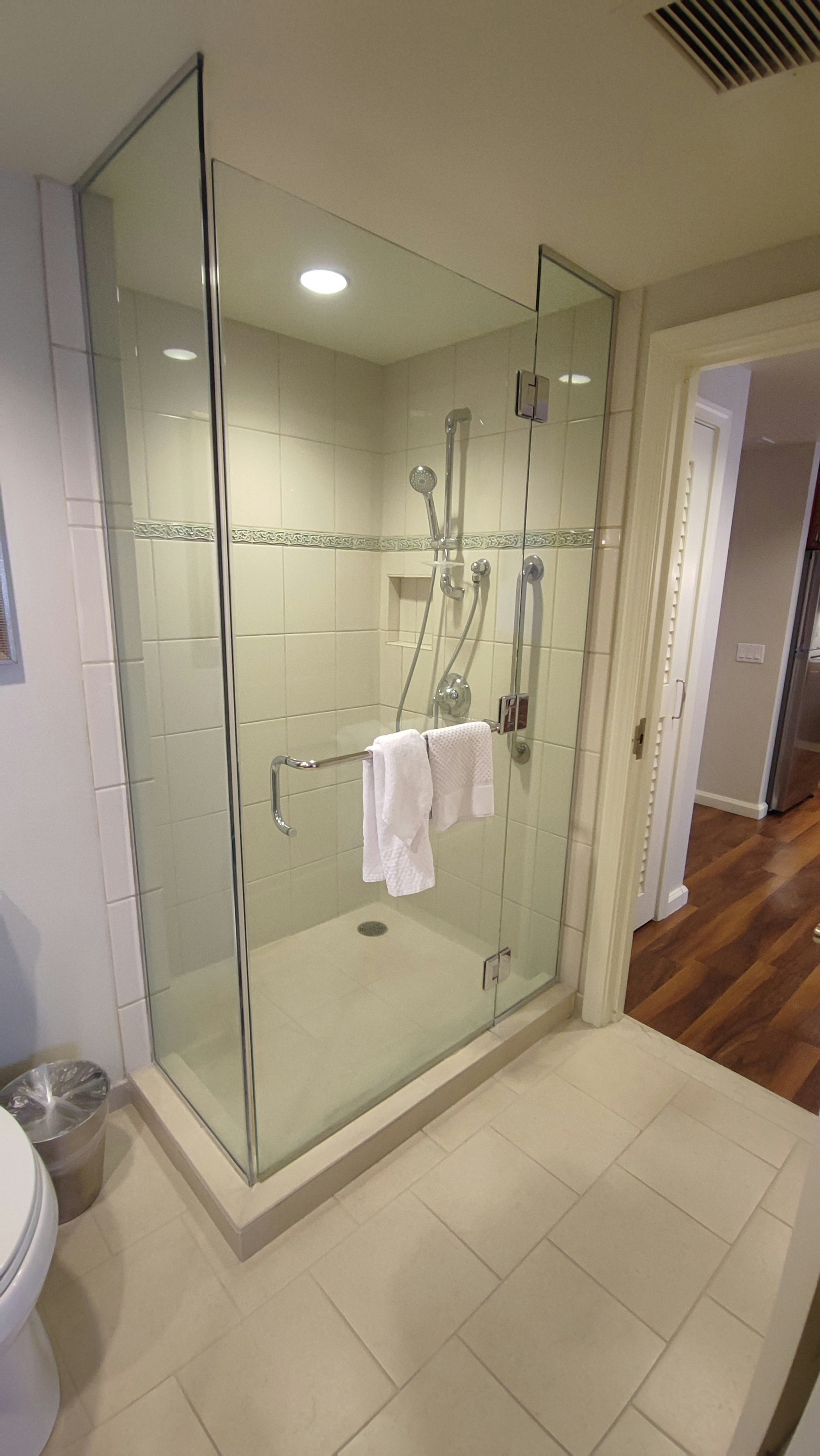 Salle de bain moderne avec cabine de douche en verre et serviette blanche