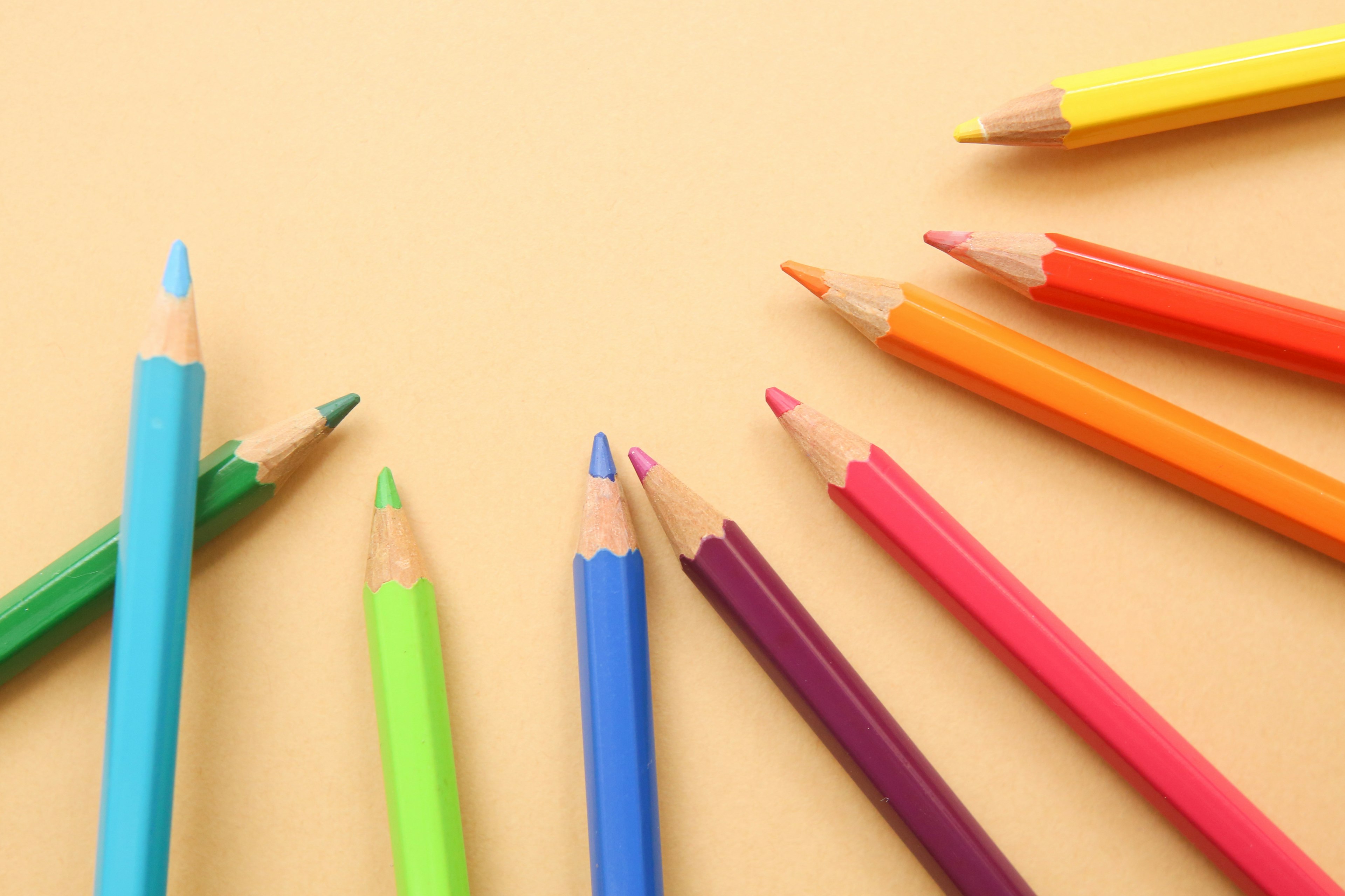 Colorful colored pencils scattered on a yellow background