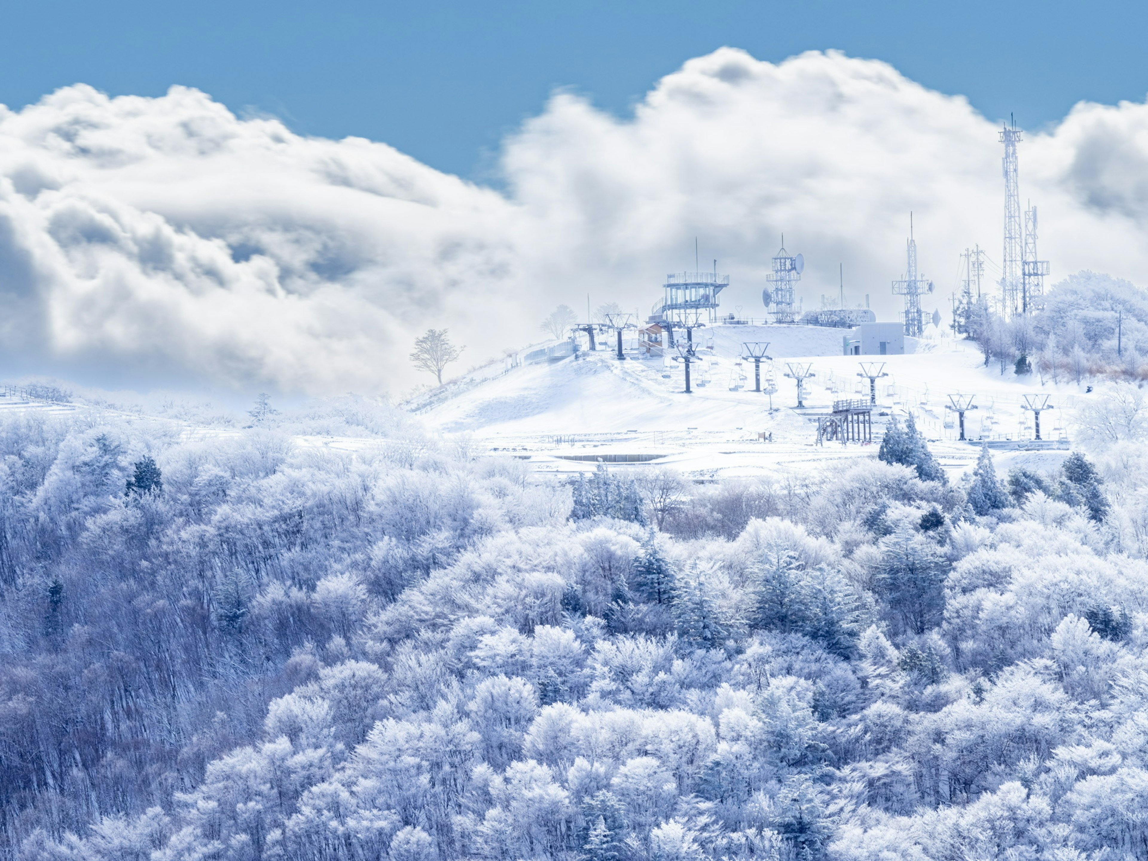 雪に覆われた山の風景に雲が漂う