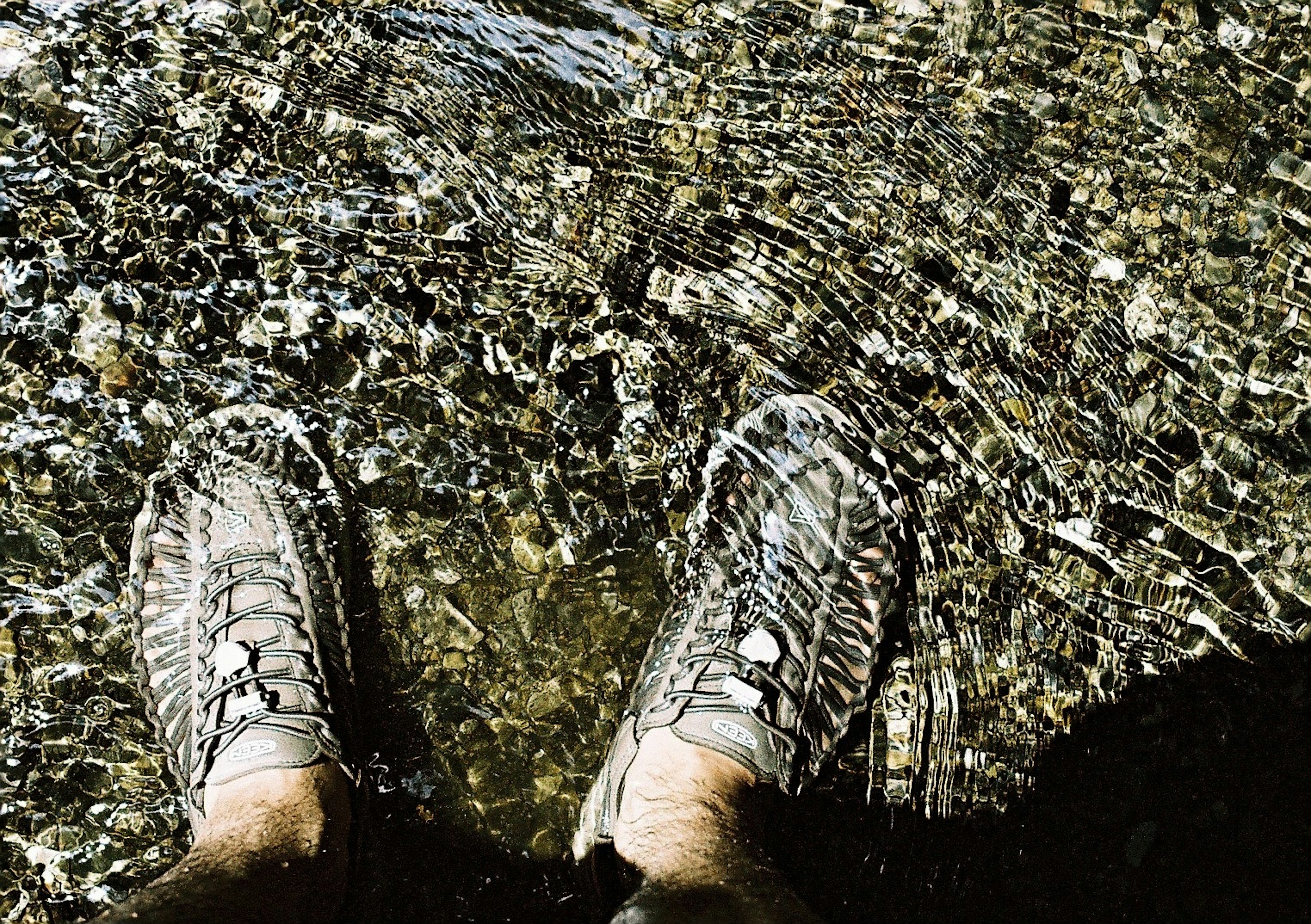 Photo de pieds dans l'eau portant des chaussures