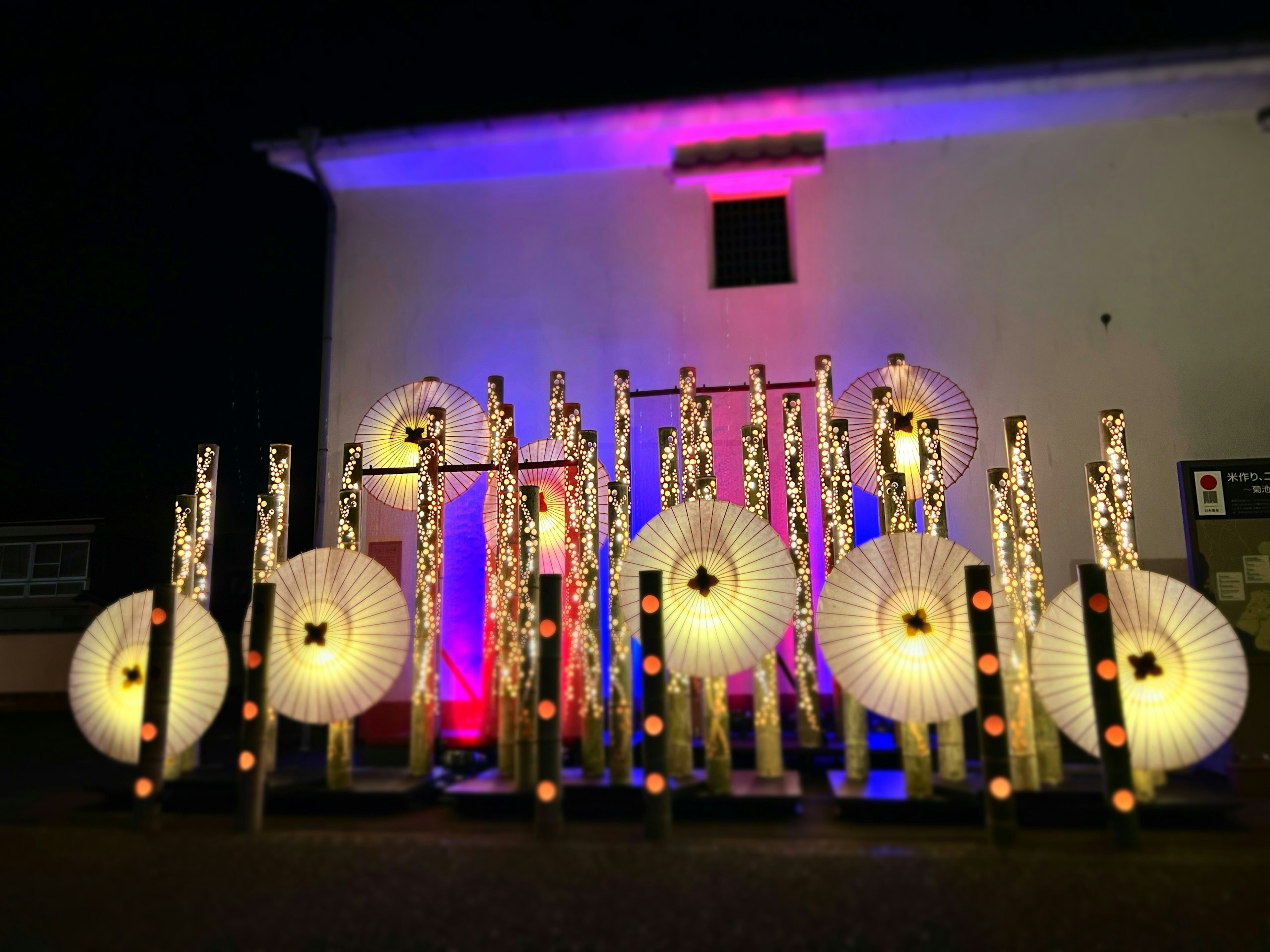 Display of illuminated Japanese-style lanterns and bamboo decorations at night