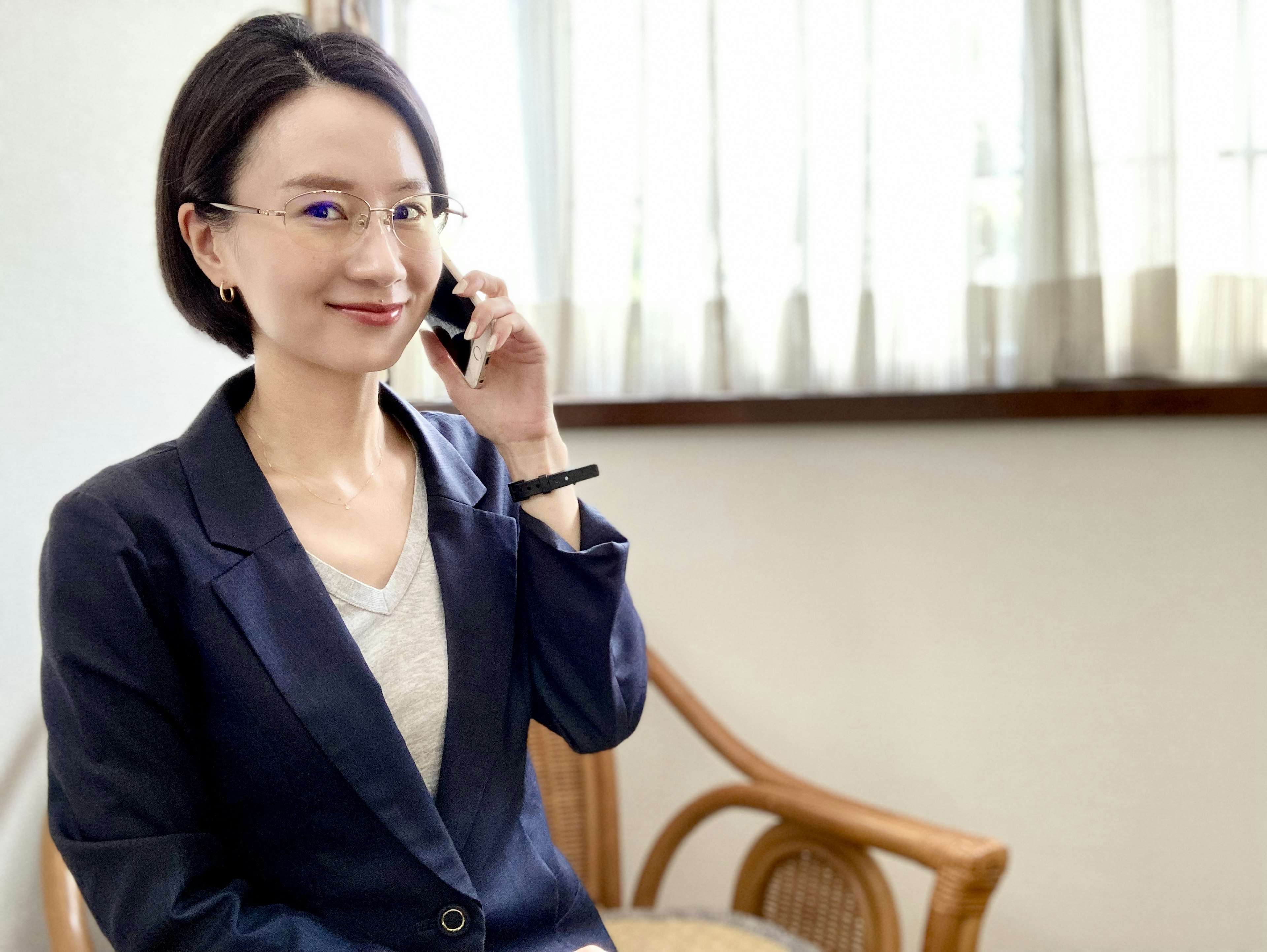 Femme d'affaires au téléphone assise près d'une fenêtre lumineuse