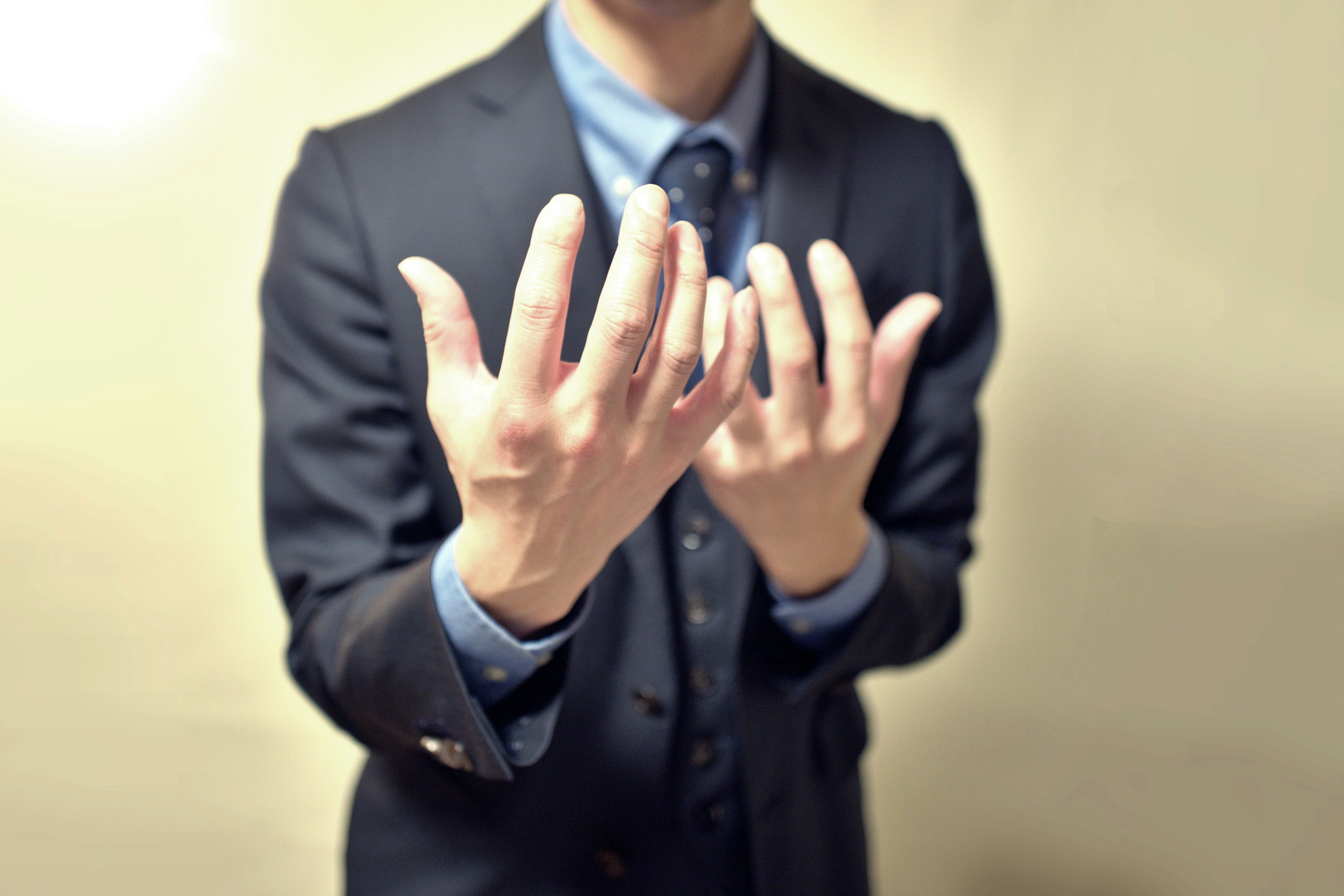 Un uomo in giacca con le mani aperte